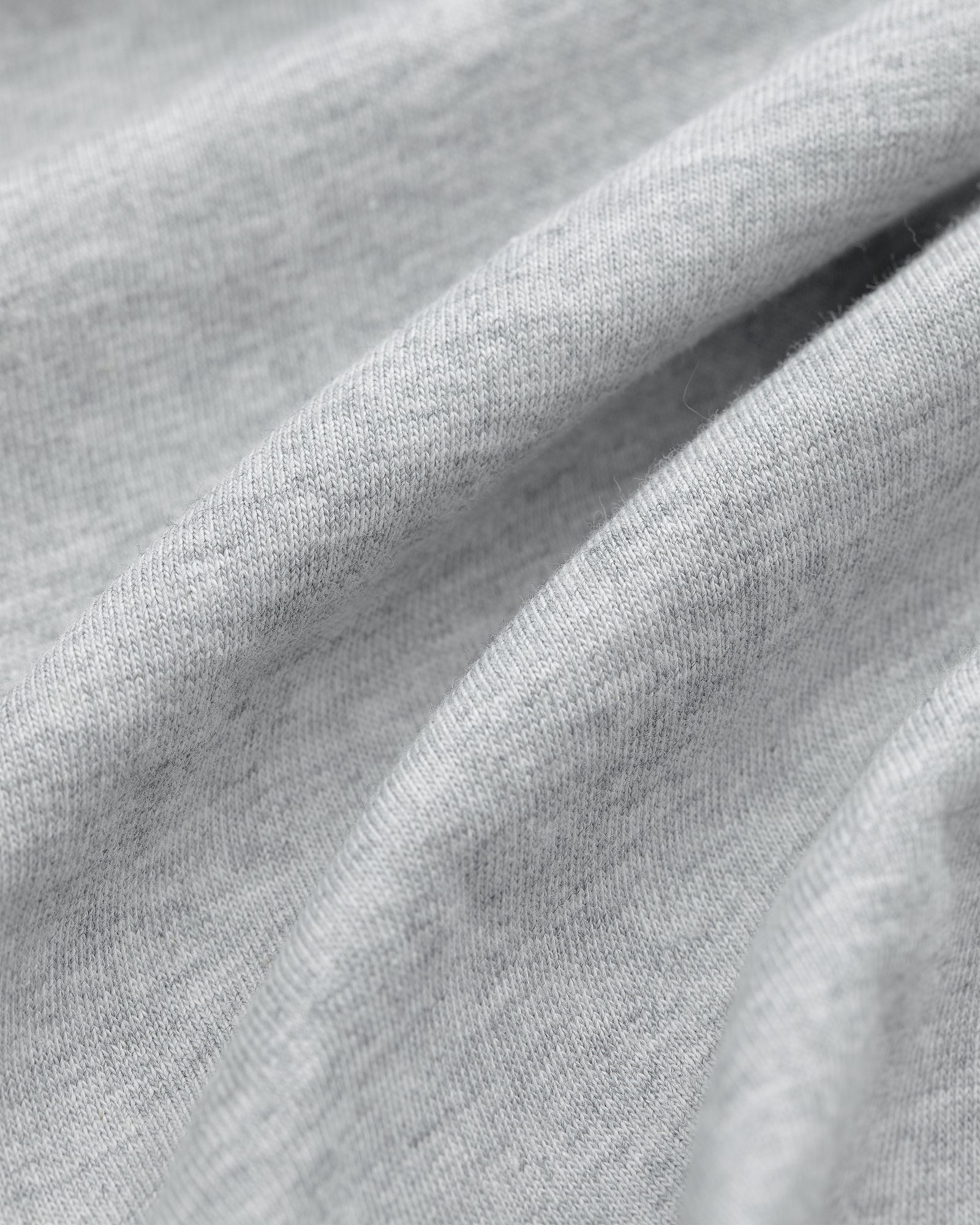 Close-up of light gray fabric from Multi-Color T-Shirt 3-Pack, with soft folds and a smooth, slightly textured surface.