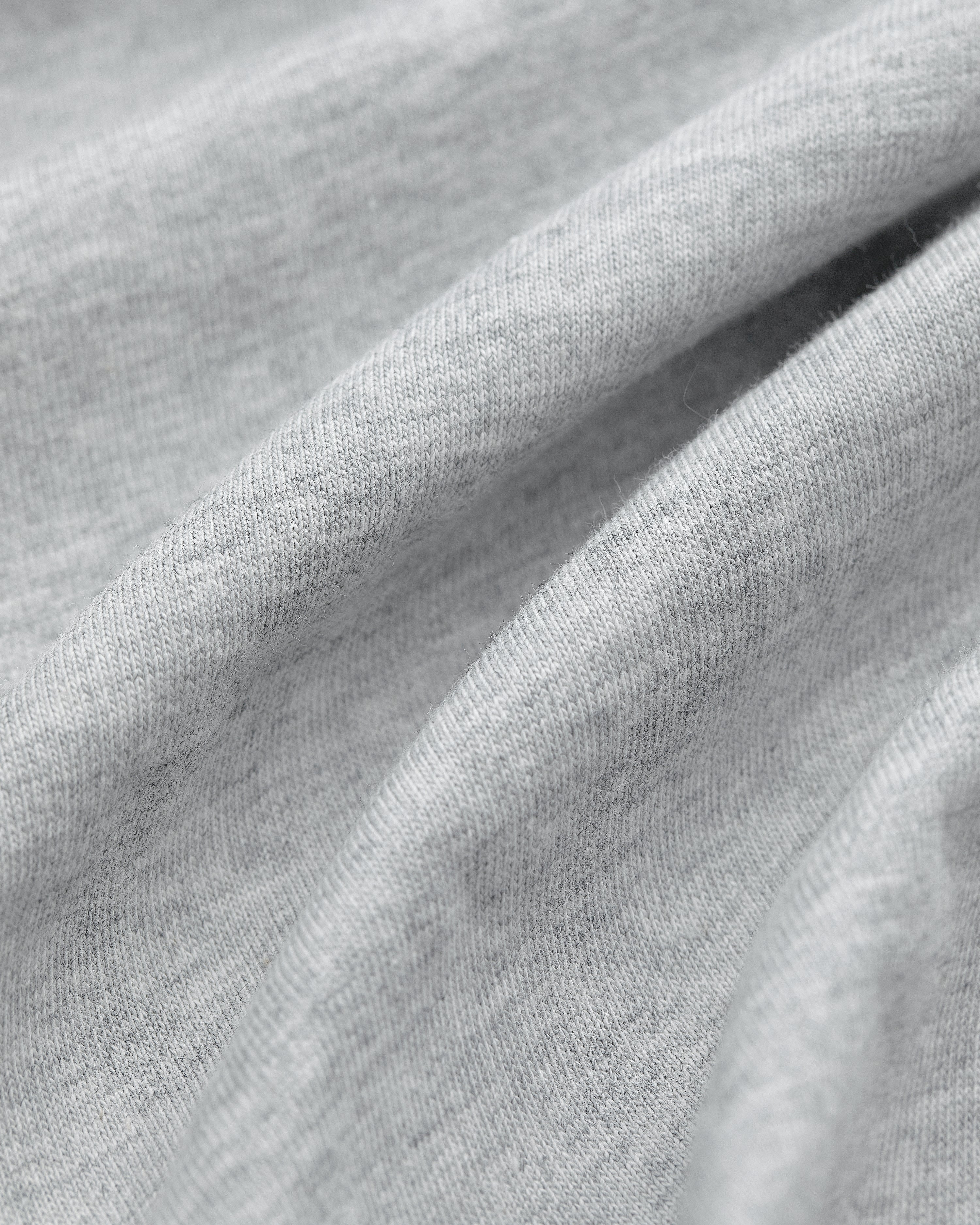 Close-up of light gray fabric from Multi-Color T-Shirt 3-Pack, with soft folds and a smooth, slightly textured surface.