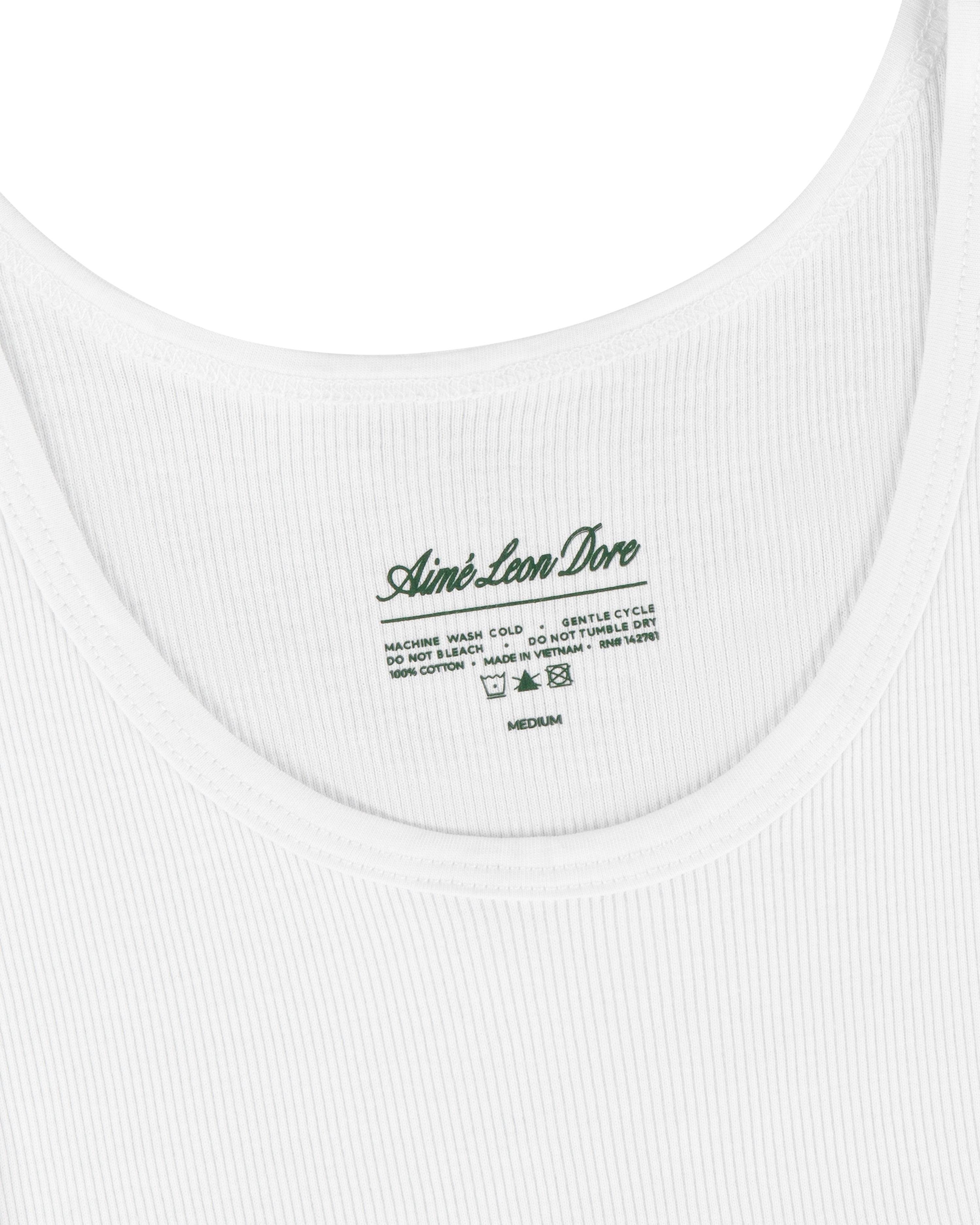 Close-up of a white Tank Top 3-Pack with a green Aimé Leon Dore label and care instructions inside the neckline.