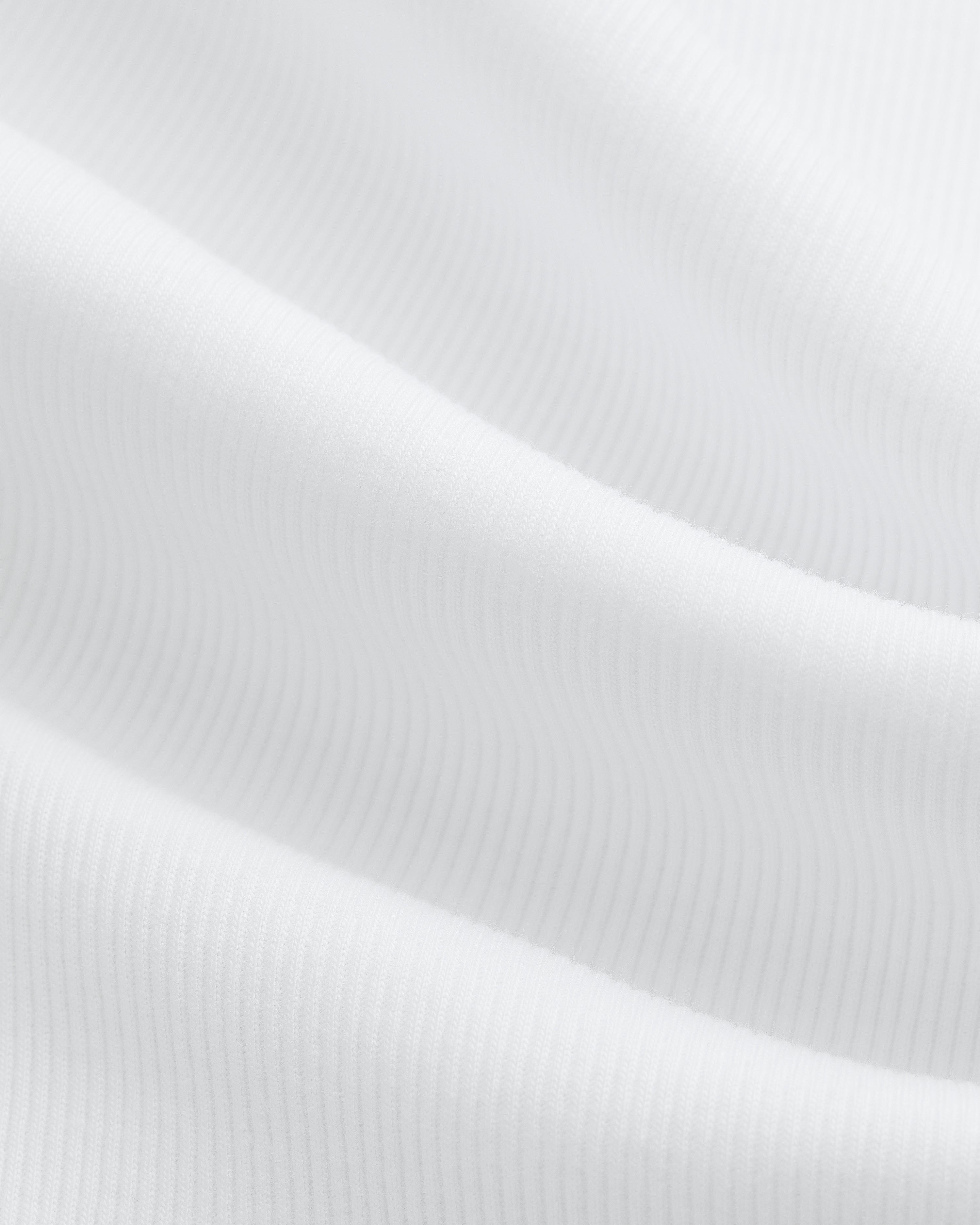 Close-up of white ribbed fabric with soft folds from the Tank Top 3-Pack.