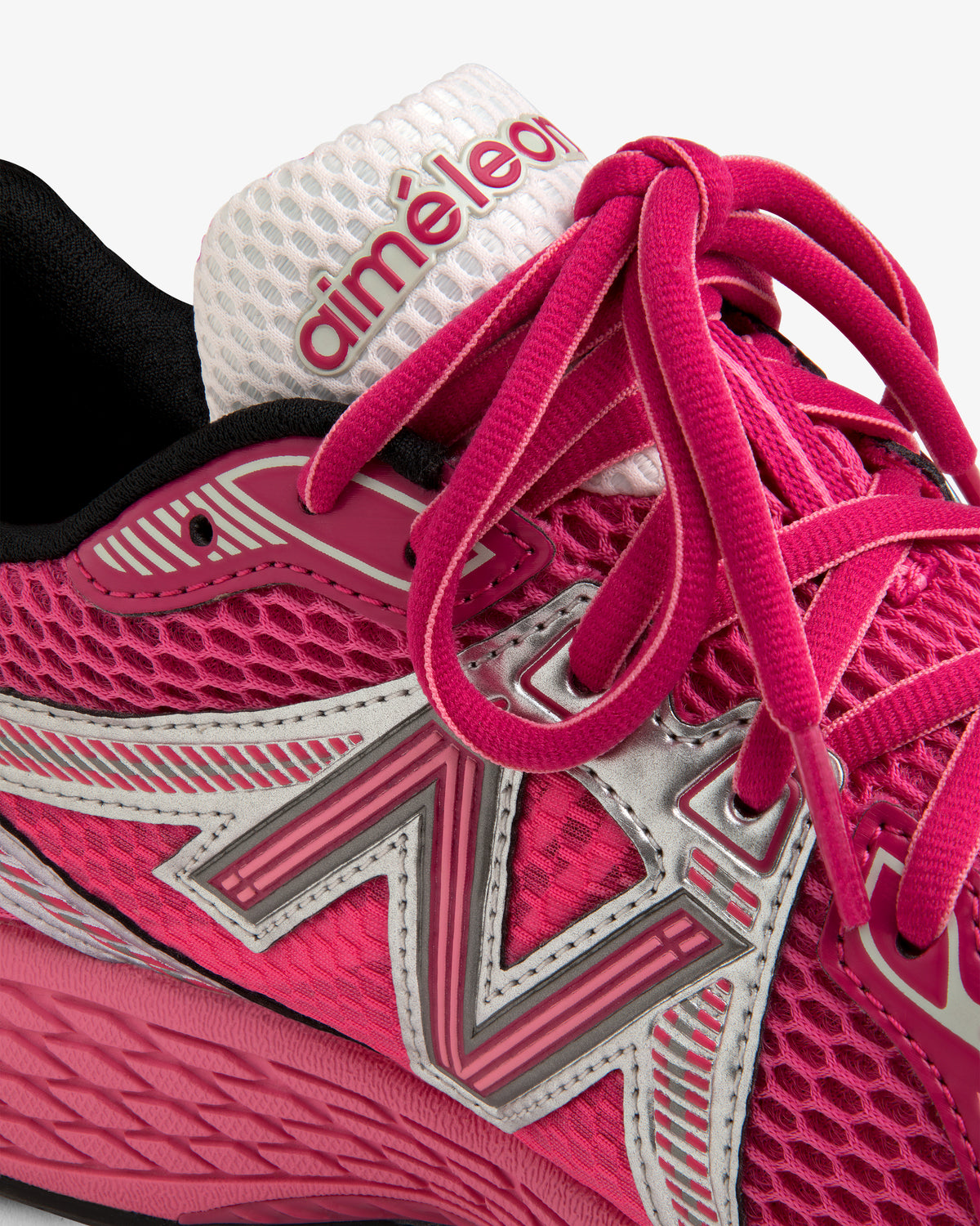 Close-up of the ALD / New Balance 860v2 pink sneaker with silver accents and branding on the white tongue.