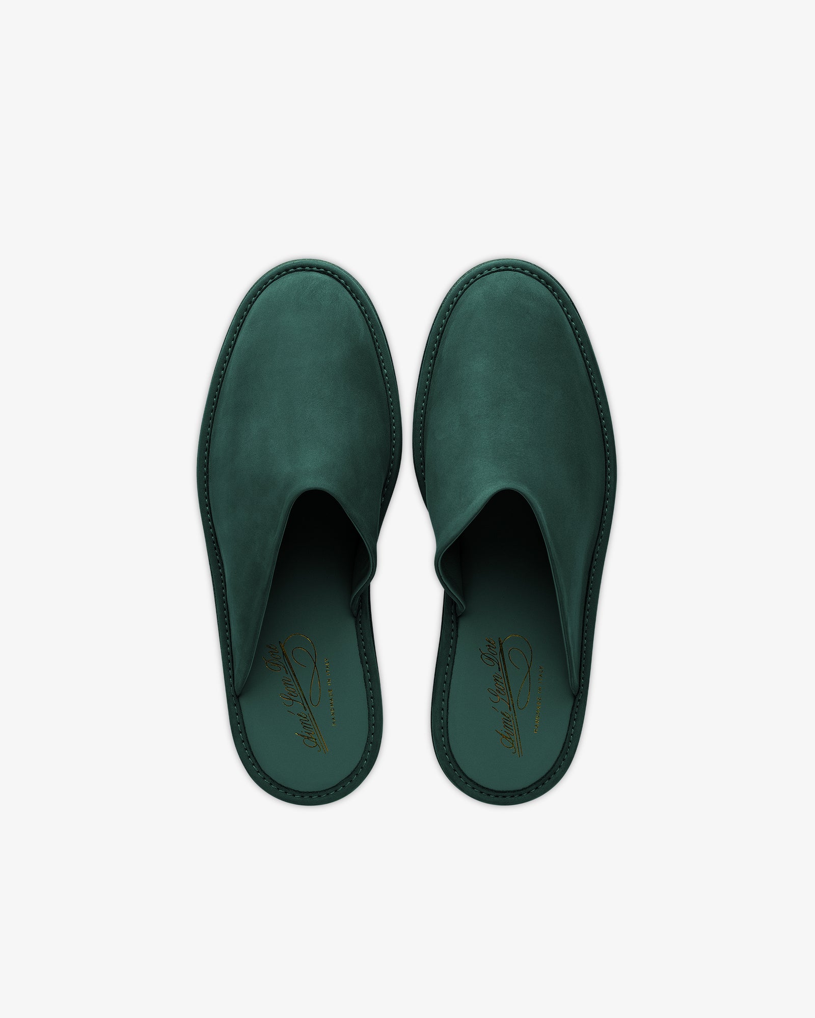A pair of green Nubuck Travel Slippers with closed toes and a gold insole logo, shown from above on a white background.