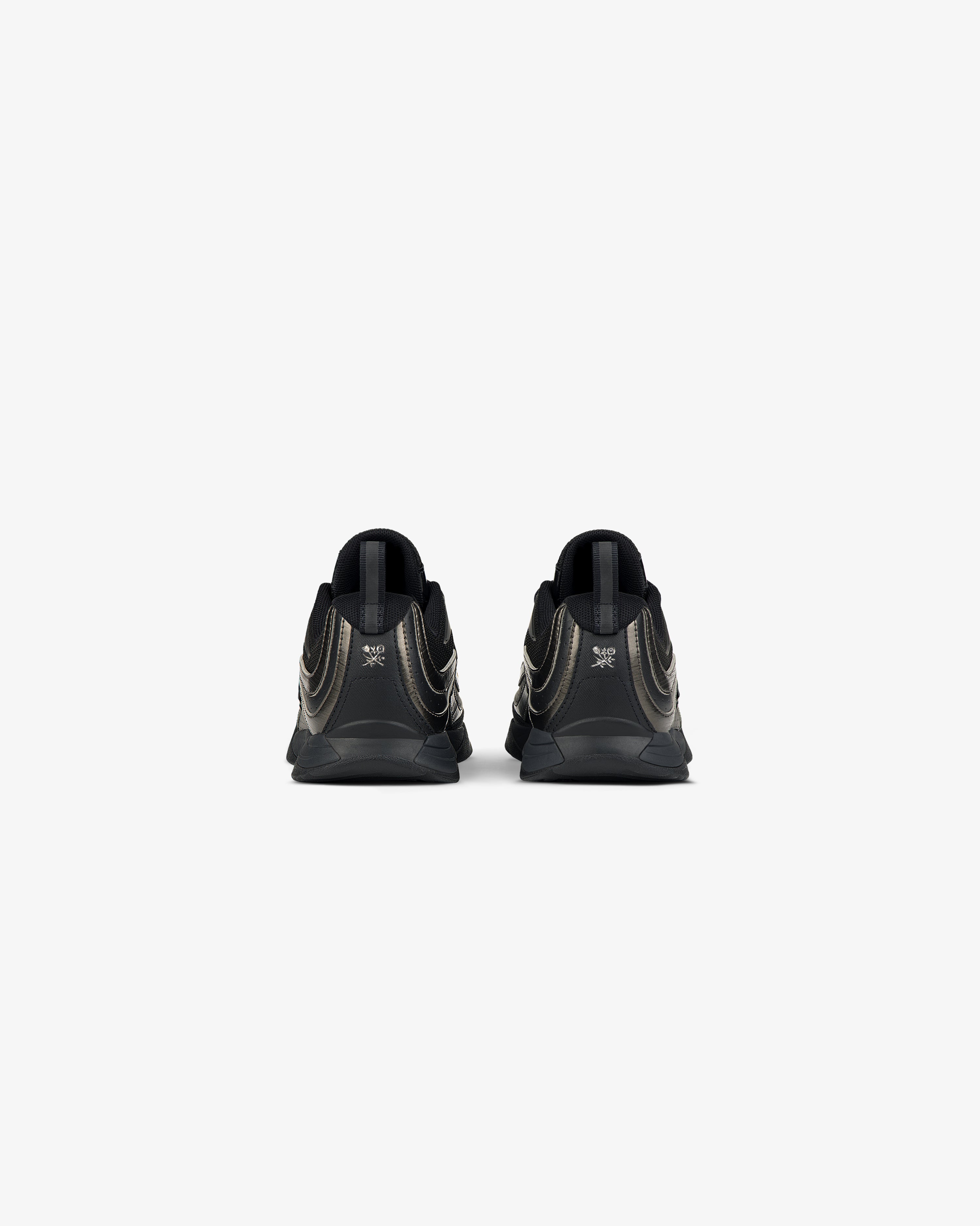 Rear view of ALD / New Balance RC56 black sneakers with metallic gold accents on a plain white background.