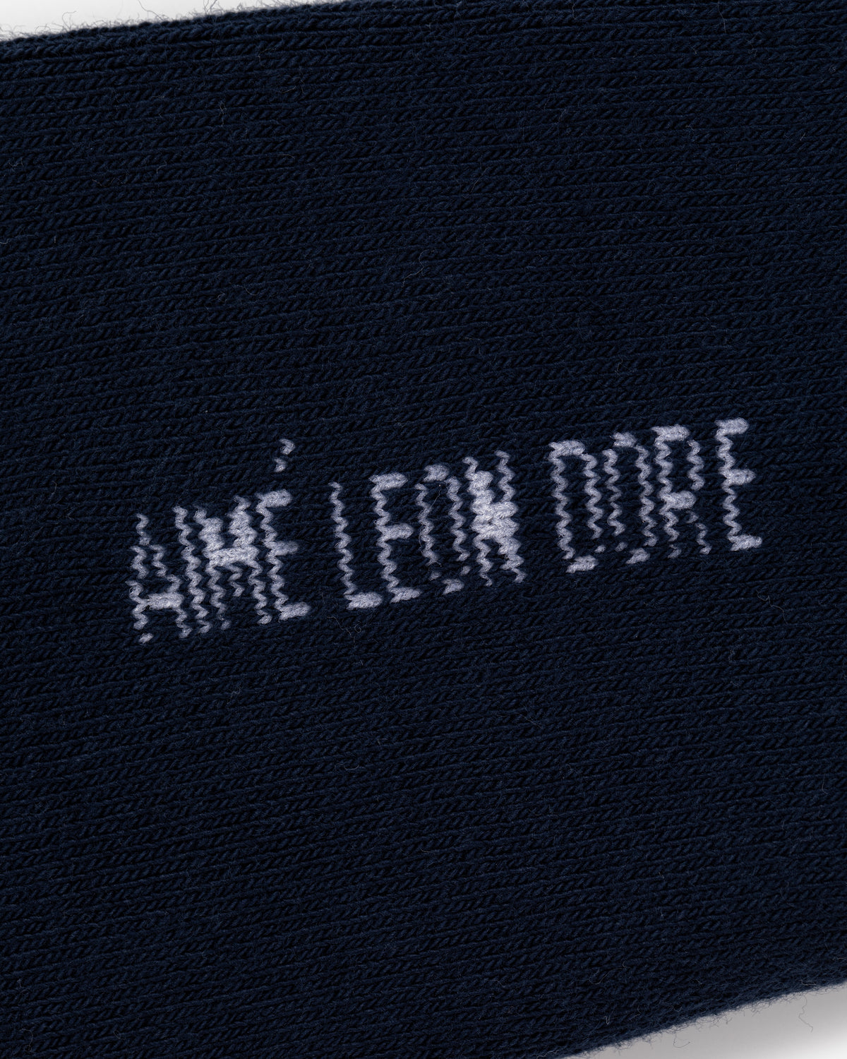 Close-up of navy blue Crew Sock 3-Pack with AIMÉ LEON DORE text stitched in white.