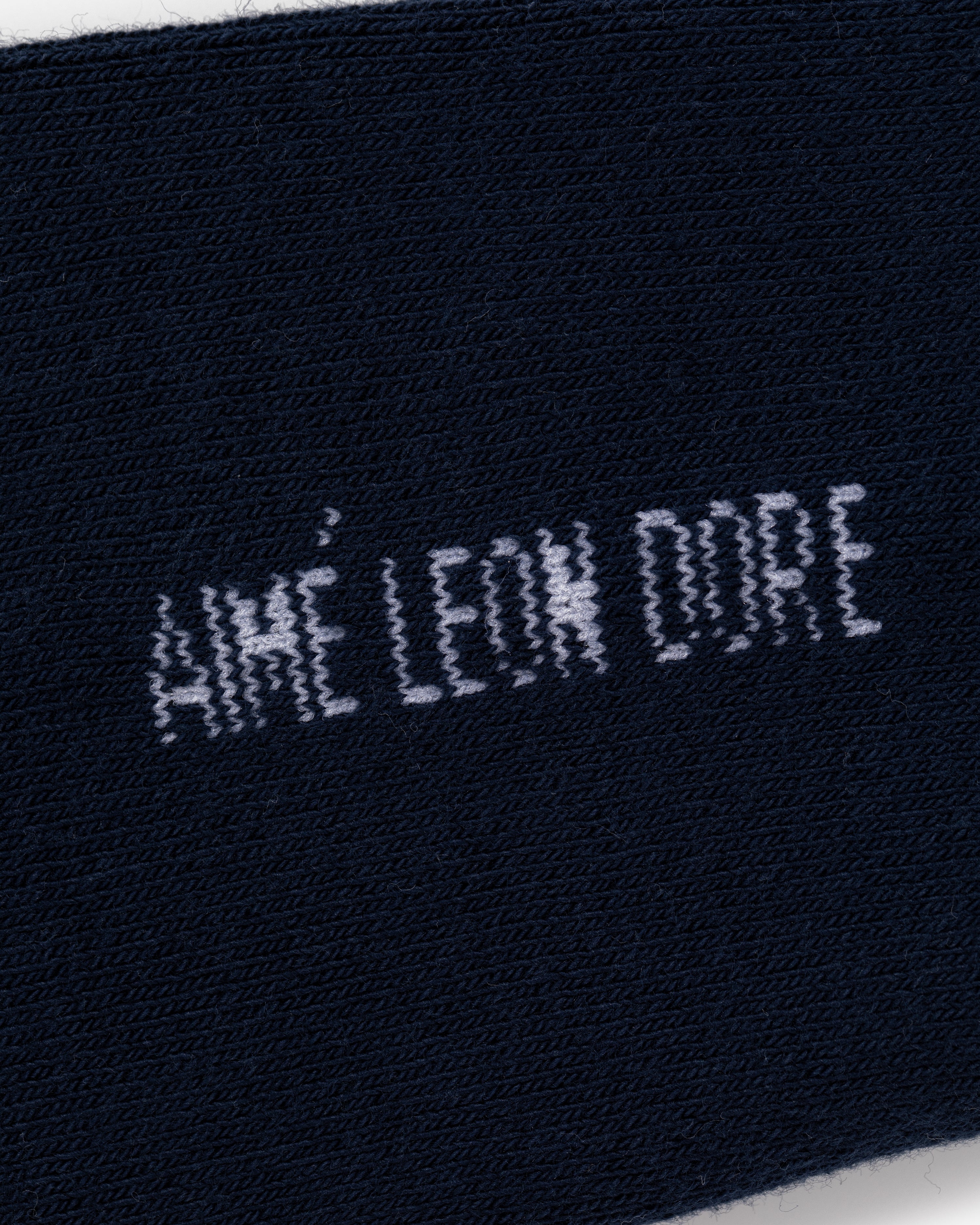 Close-up of navy blue Crew Sock 3-Pack with AIMÉ LEON DORE text stitched in white.