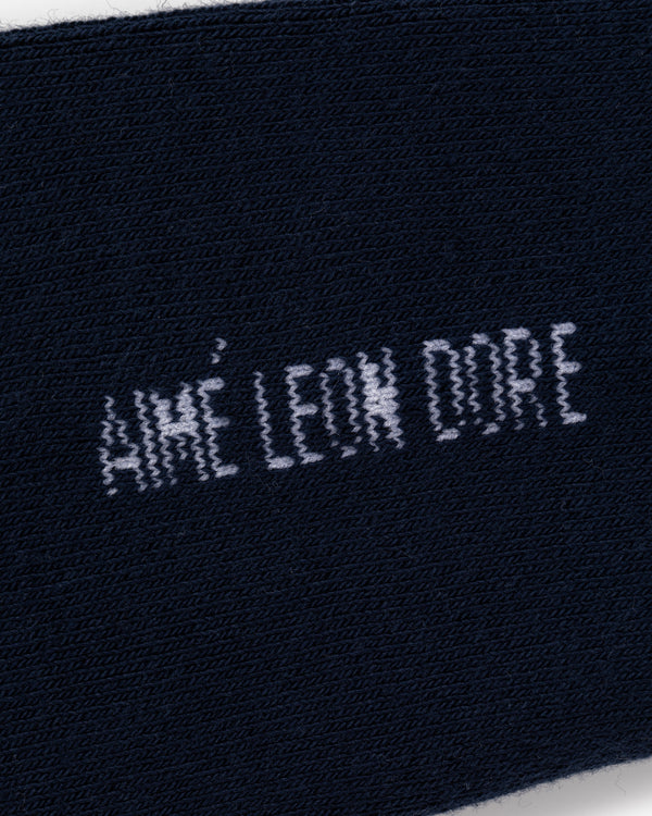 Close-up of navy blue Crew Sock 3-Pack with AIMÉ LEON DORE text stitched in white.