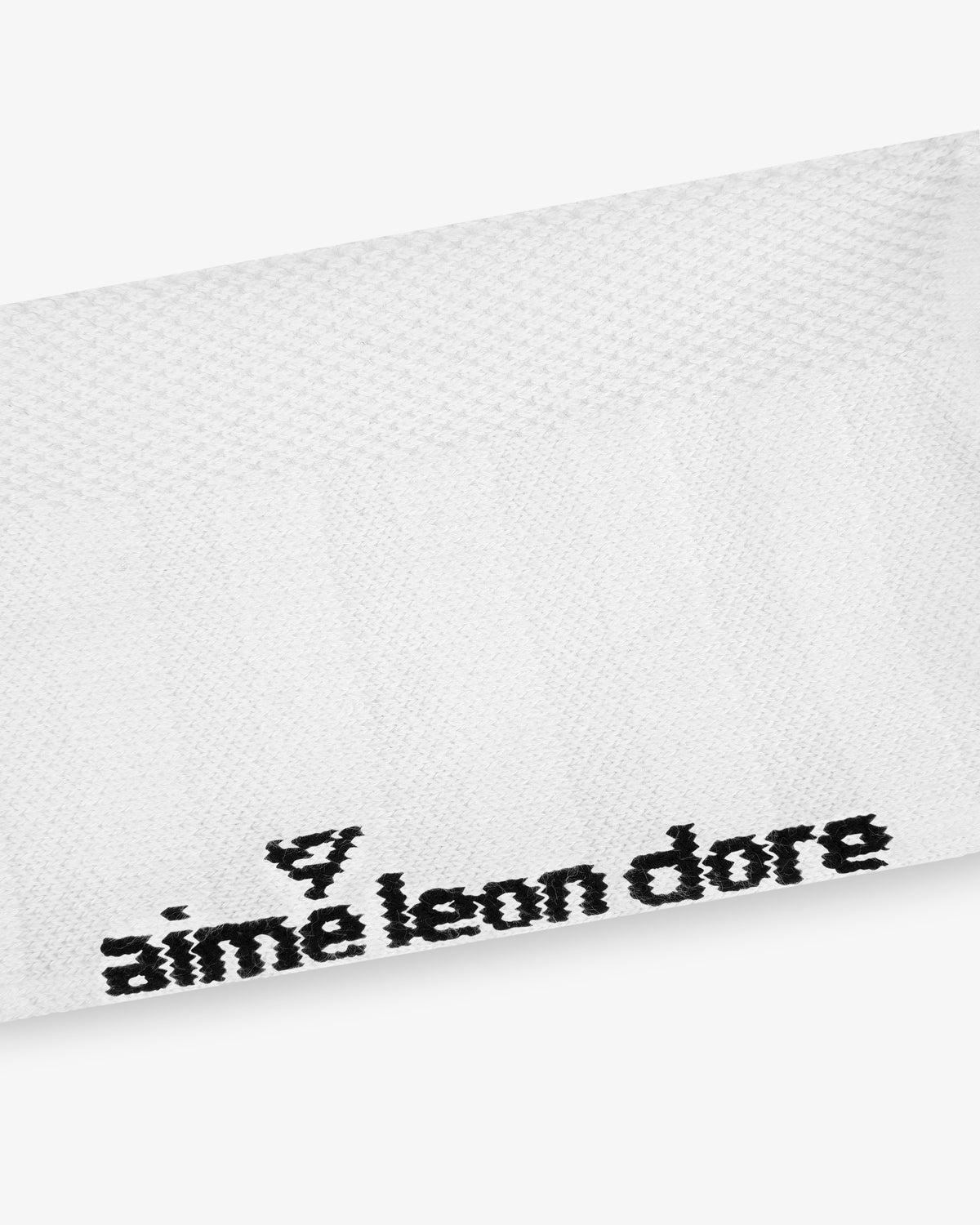 White textured ALD Golf Performance Ankle Sock with a small black stitched triangular logo at the corner.