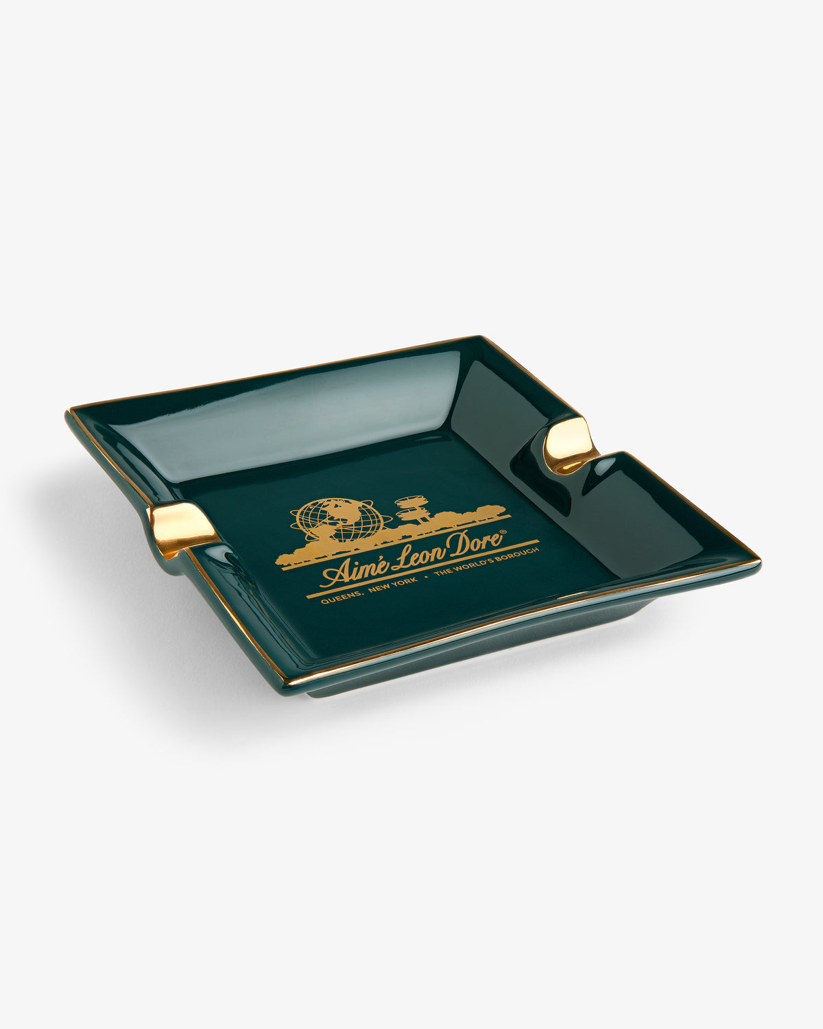 Dark green Unisphere Ashtray with gold accents and Aimé Leon Dore logo in gold at the center on a white background.