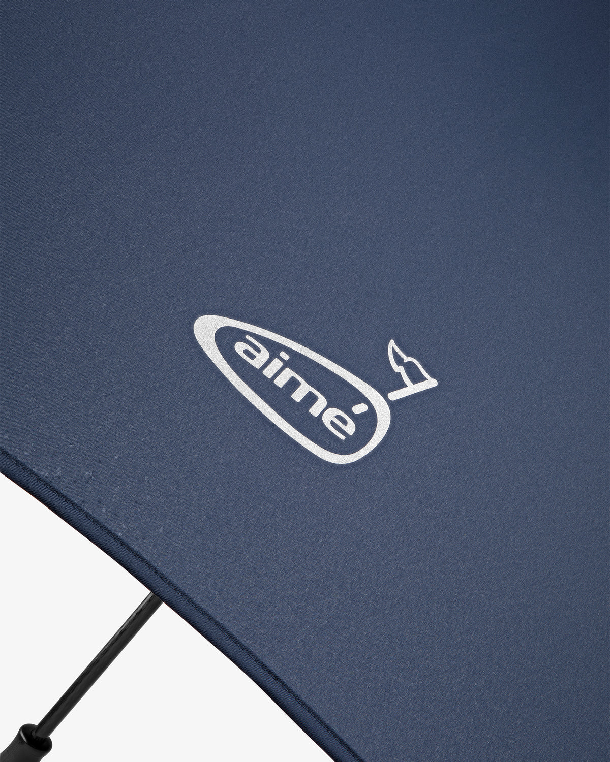 Close-up of the ALD Golf Spectator Umbrella in navy blue with "aimé" and a small bird logo printed in white.