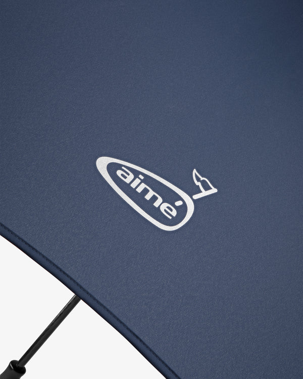 Close-up of the ALD Golf Spectator Umbrella in navy blue with "aimé" and a small bird logo printed in white.