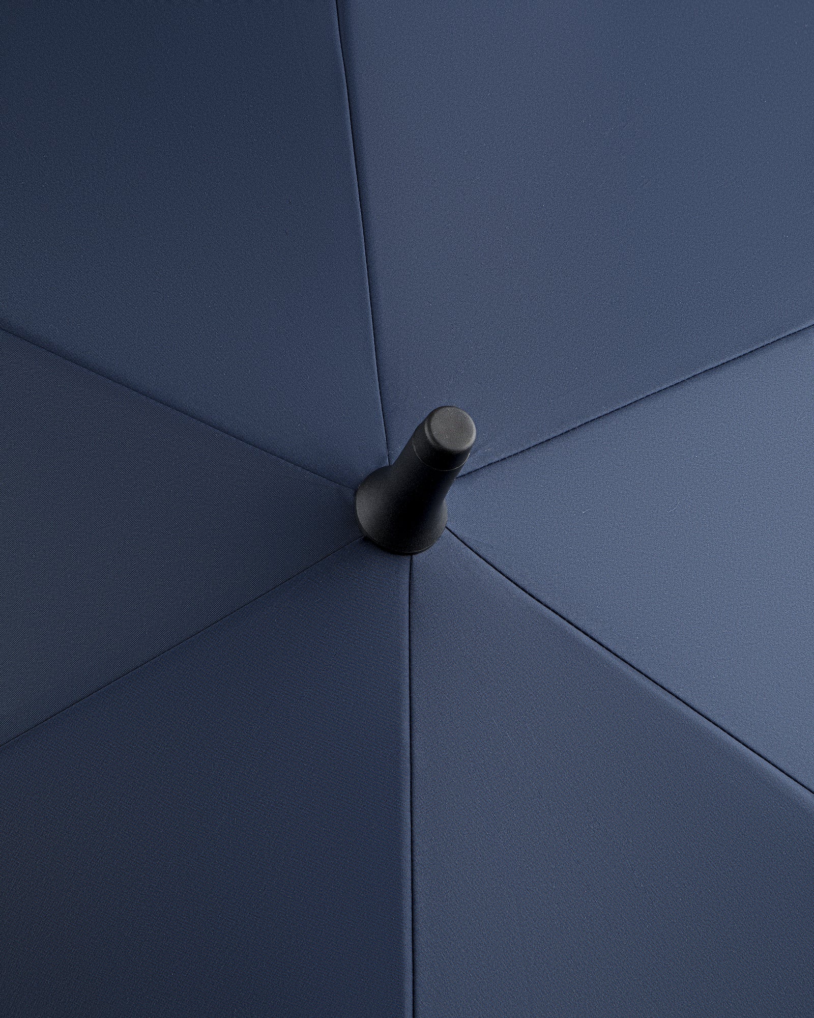 Close-up of the ALD Golf Spectator Umbrella's top center, highlighting its dark blue fabric panels and central tip.