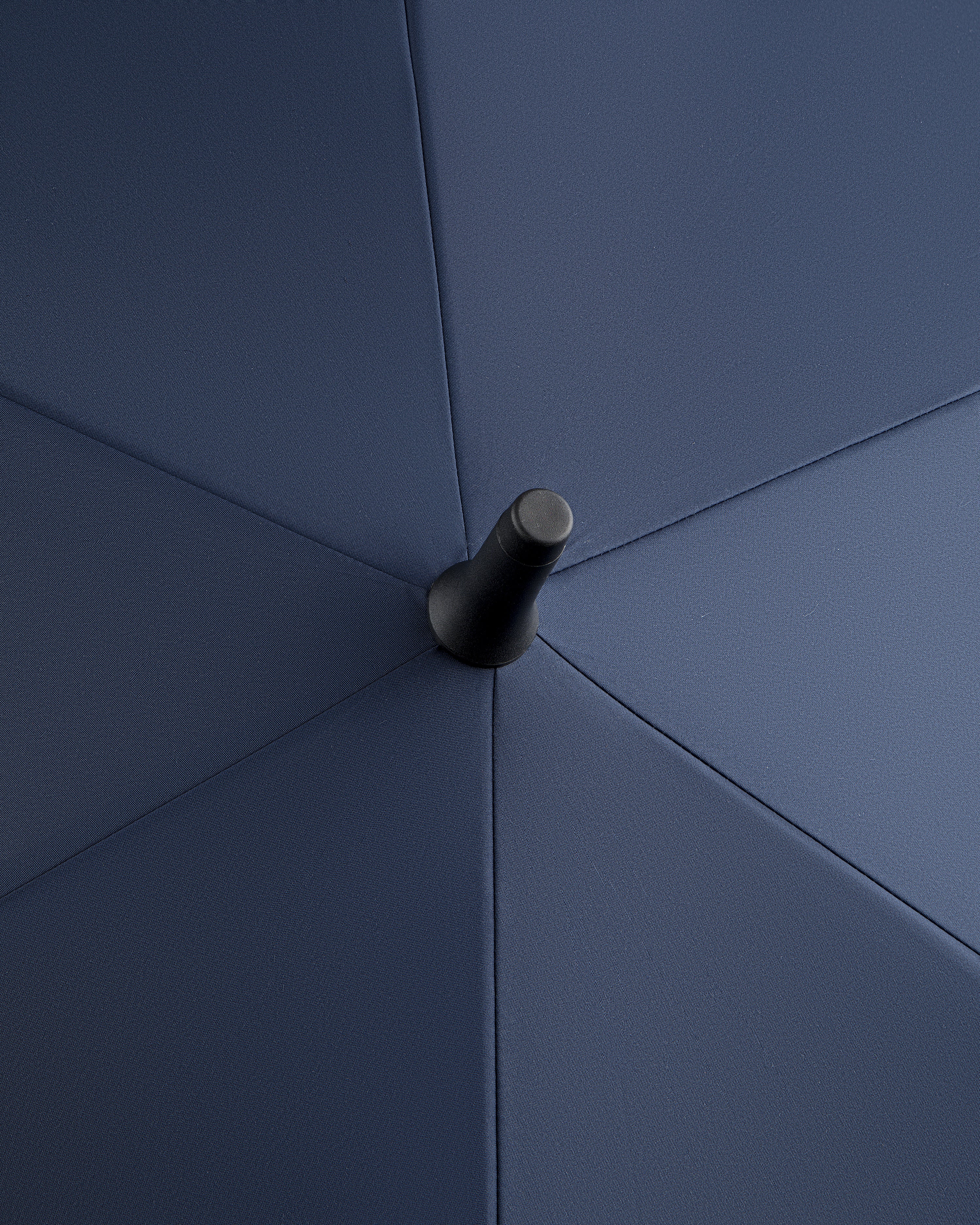 Close-up of the ALD Golf Spectator Umbrella's top center, highlighting its dark blue fabric panels and central tip.