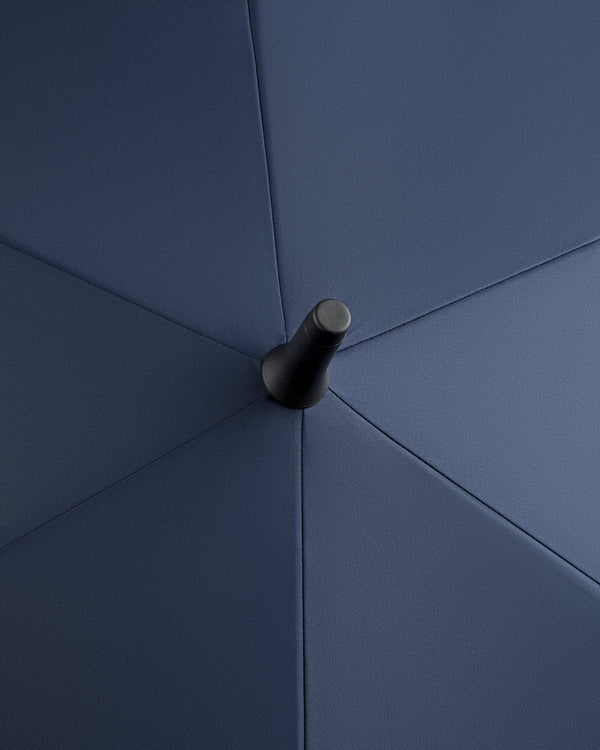 Close-up of the ALD Golf Spectator Umbrella's top center, highlighting its dark blue fabric panels and central tip.