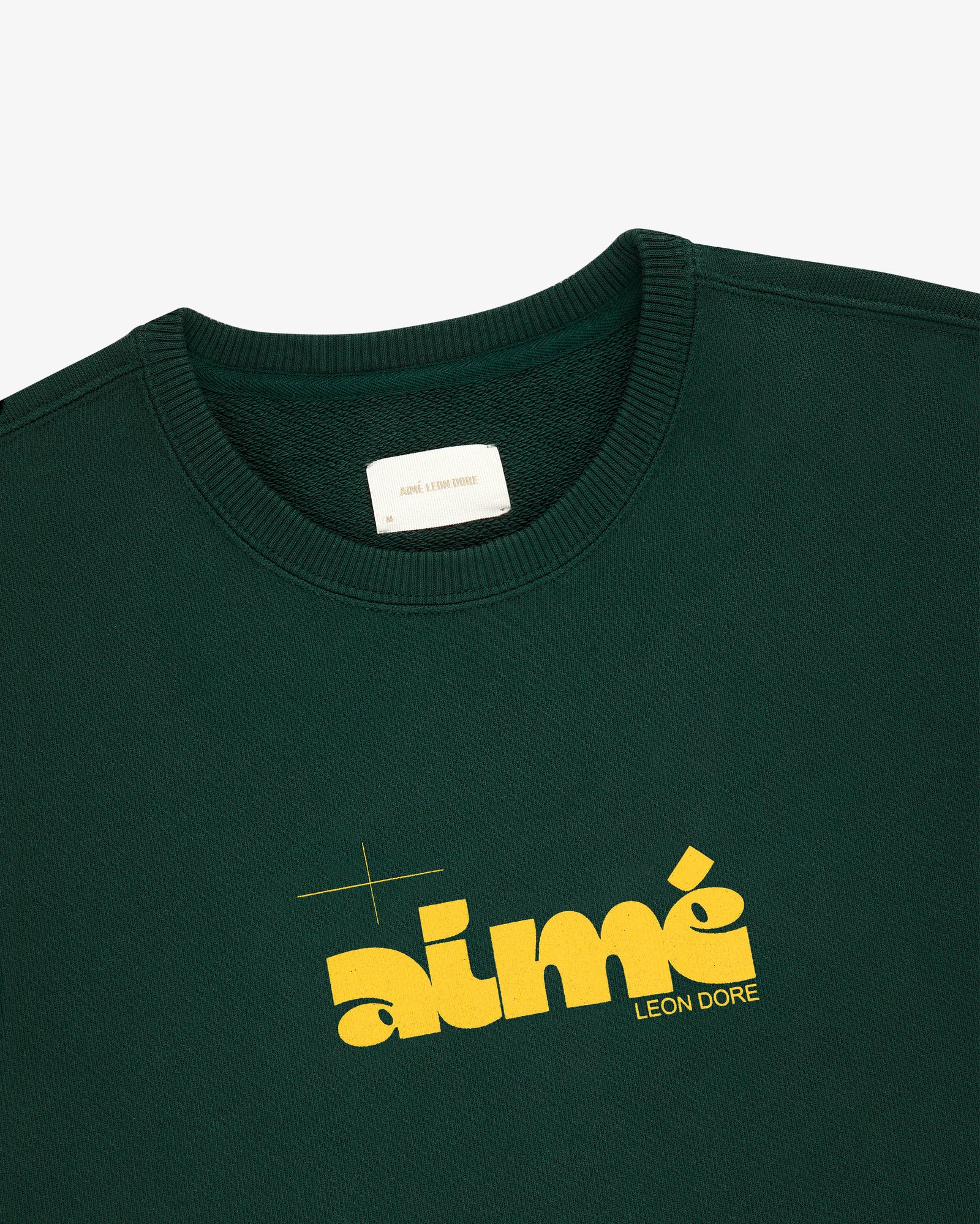 Drafting Logo Crewneck Sweatshirt in dark green with bold yellow aimé LEON DORE print on the front.