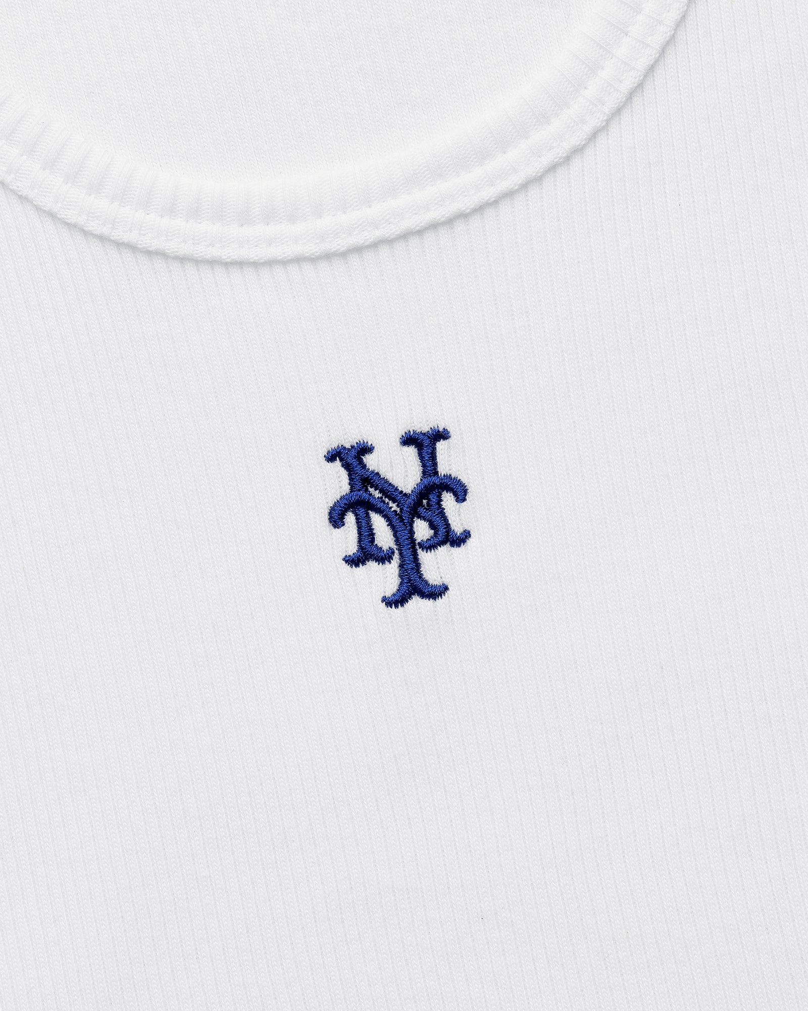 Close-up of the Mets Tank Top, a white ribbed shirt featuring a blue New York Mets logo embroidered on the chest.
