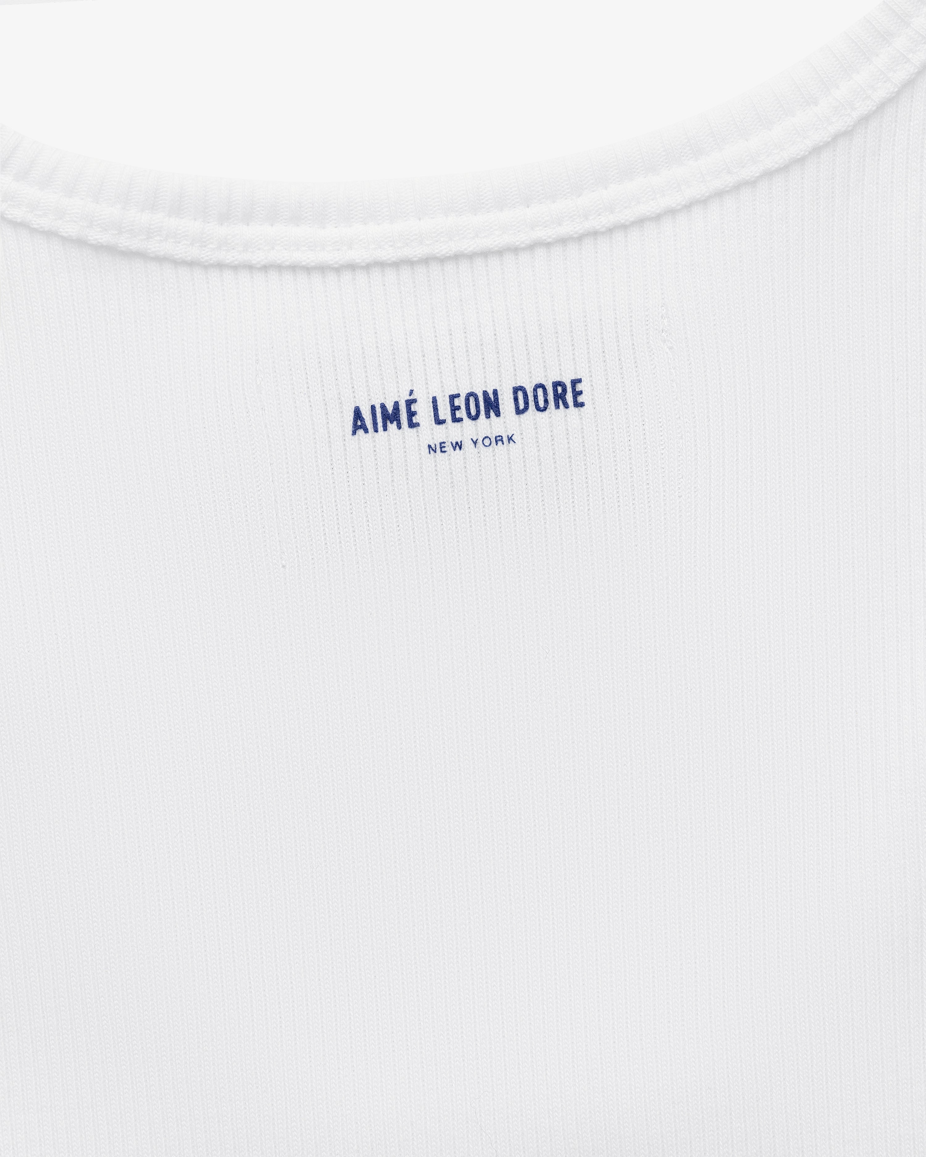 Close-up of the back neck area of the white Mets Tank Top with AIMÉ LEON DORE NEW YORK printed in blue text.