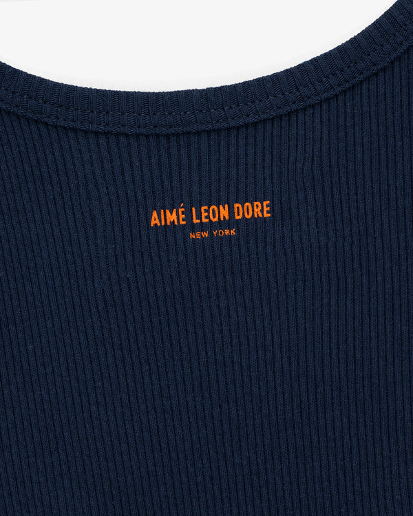 Close-up of the Mets Tank Top in navy ribbed fabric with orange AIMÉ LEON DORE NEW YORK text near the collar.