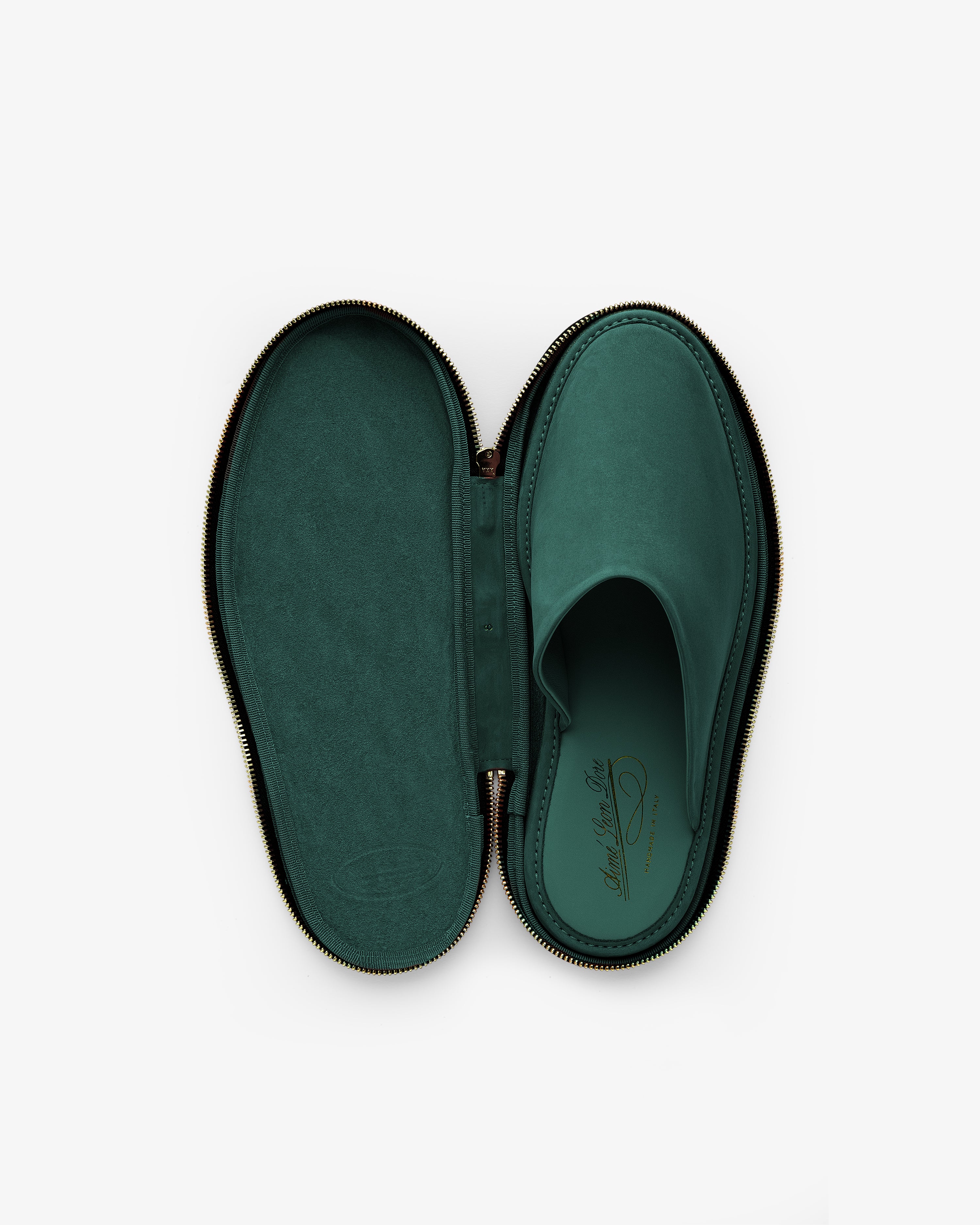 A single Nubuck Travel Slipper in green, placed inside an oval, zippered case matching its shape and color.