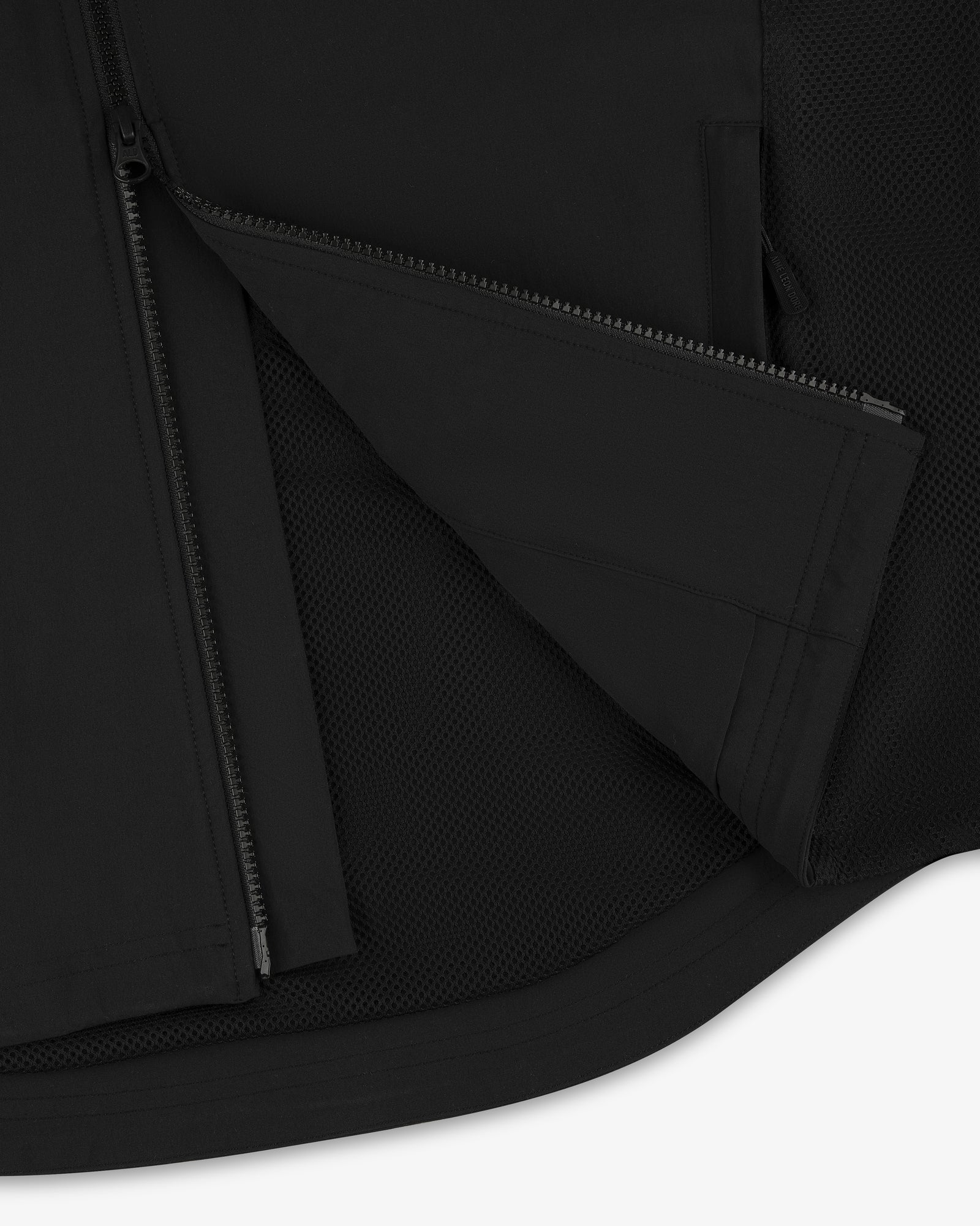 Close-up of ALD Golf Cordura Tips Jacket in black, featuring a partially unzipped zipper and mesh fabric lining.