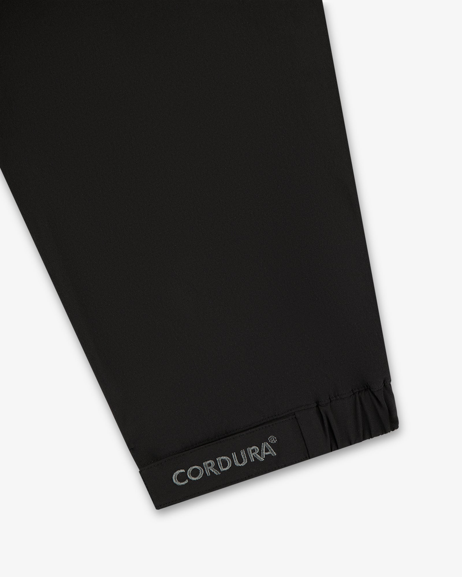 Black CORDURA fabric near gathered hem, from the ALD Golf Cordura Tips Jacket—likely part of sleeve or pant leg.