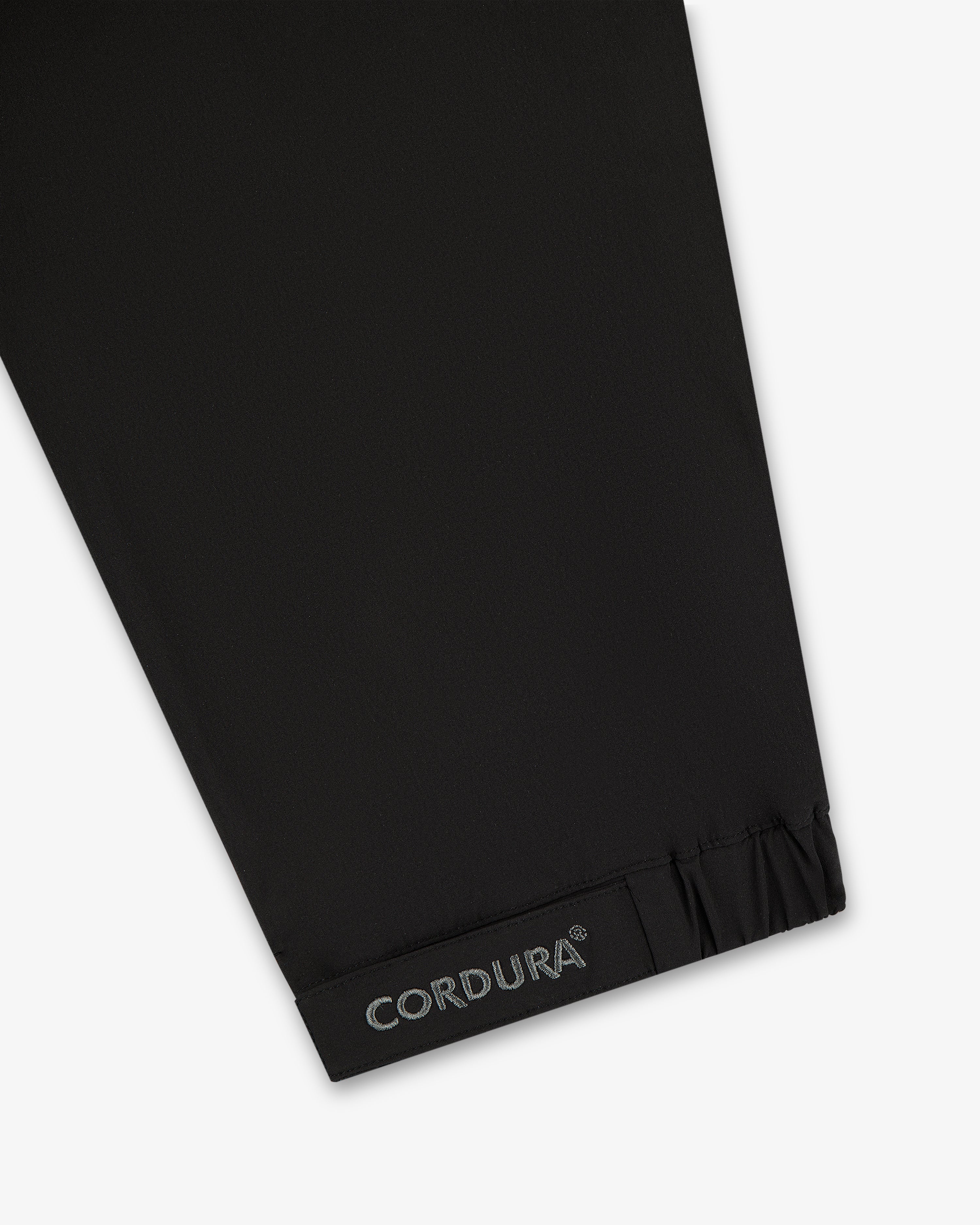 Black CORDURA fabric near gathered hem, from the ALD Golf Cordura Tips Jacket—likely part of sleeve or pant leg.