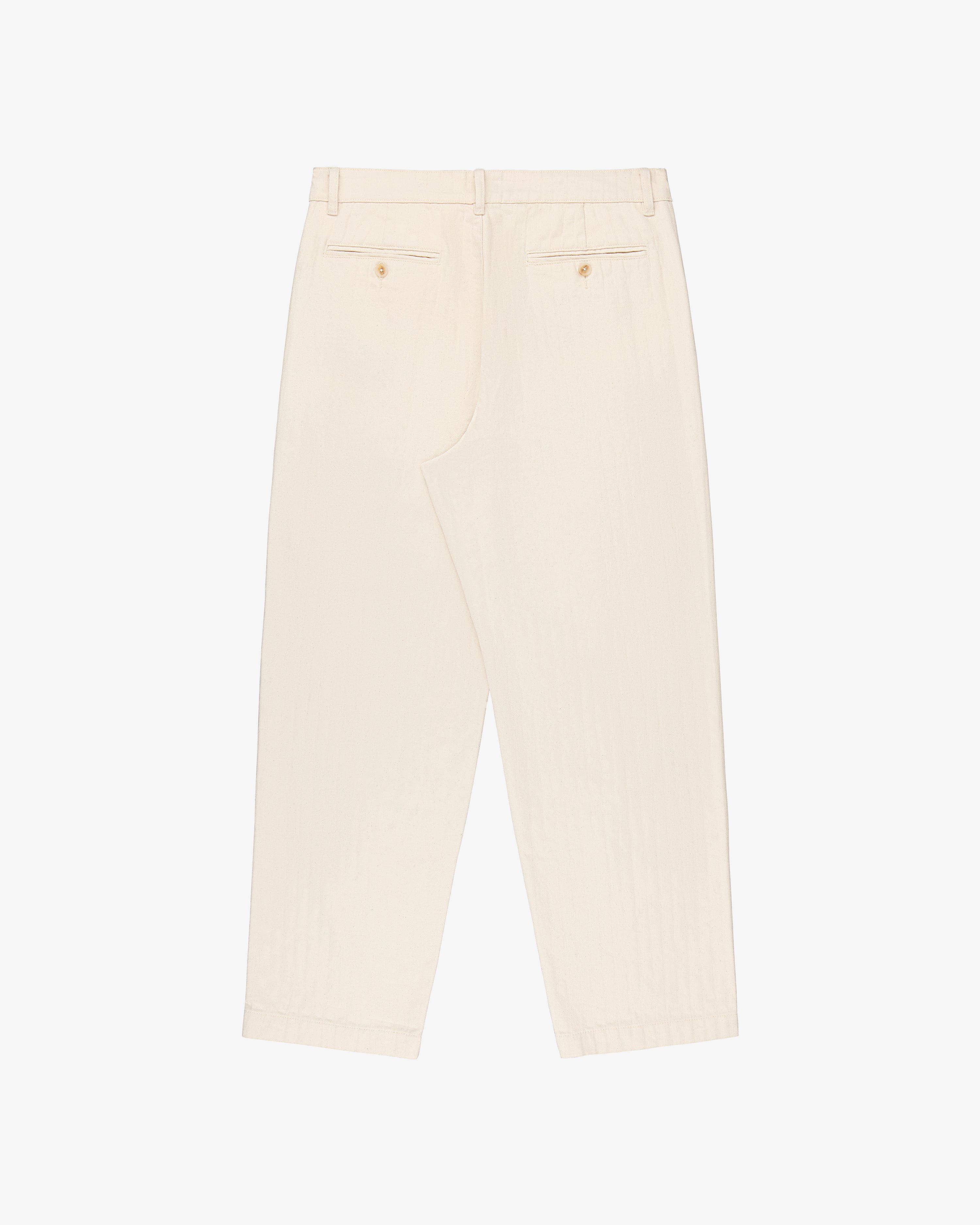 Back view of Single Pleated Pant in off-white with belt loops & two buttoned back pockets, laid flat on white background.