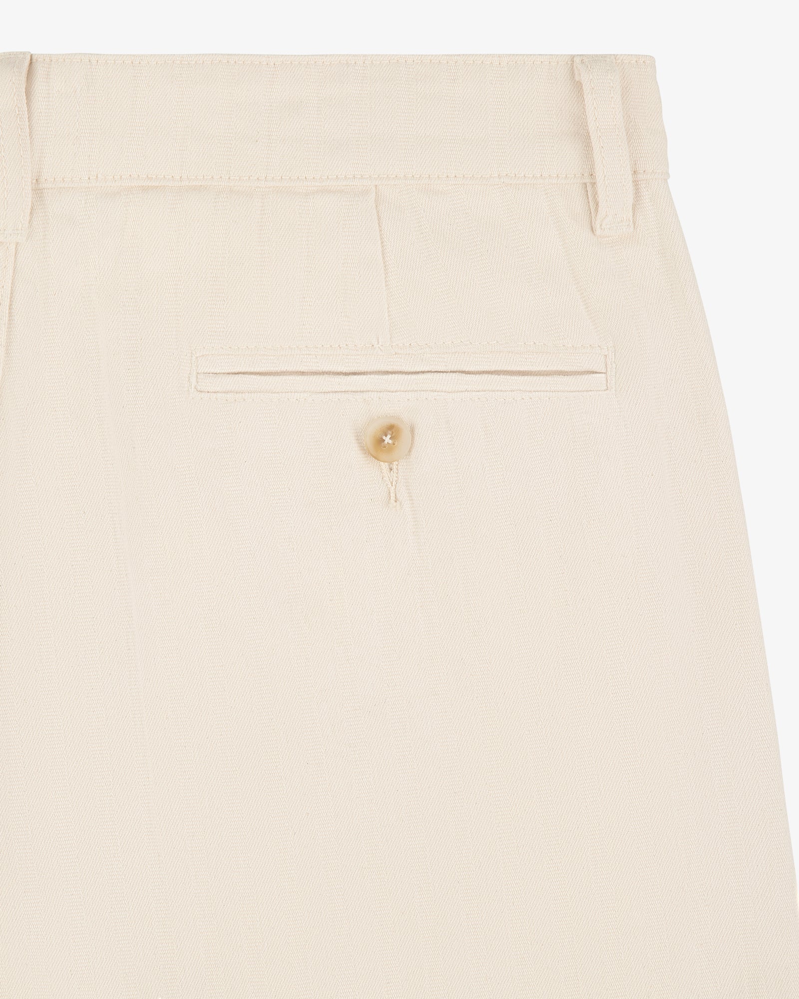 Close-up of Single Pleated Pant in beige, highlighting the back pocket with button and belt loop at the waistband.