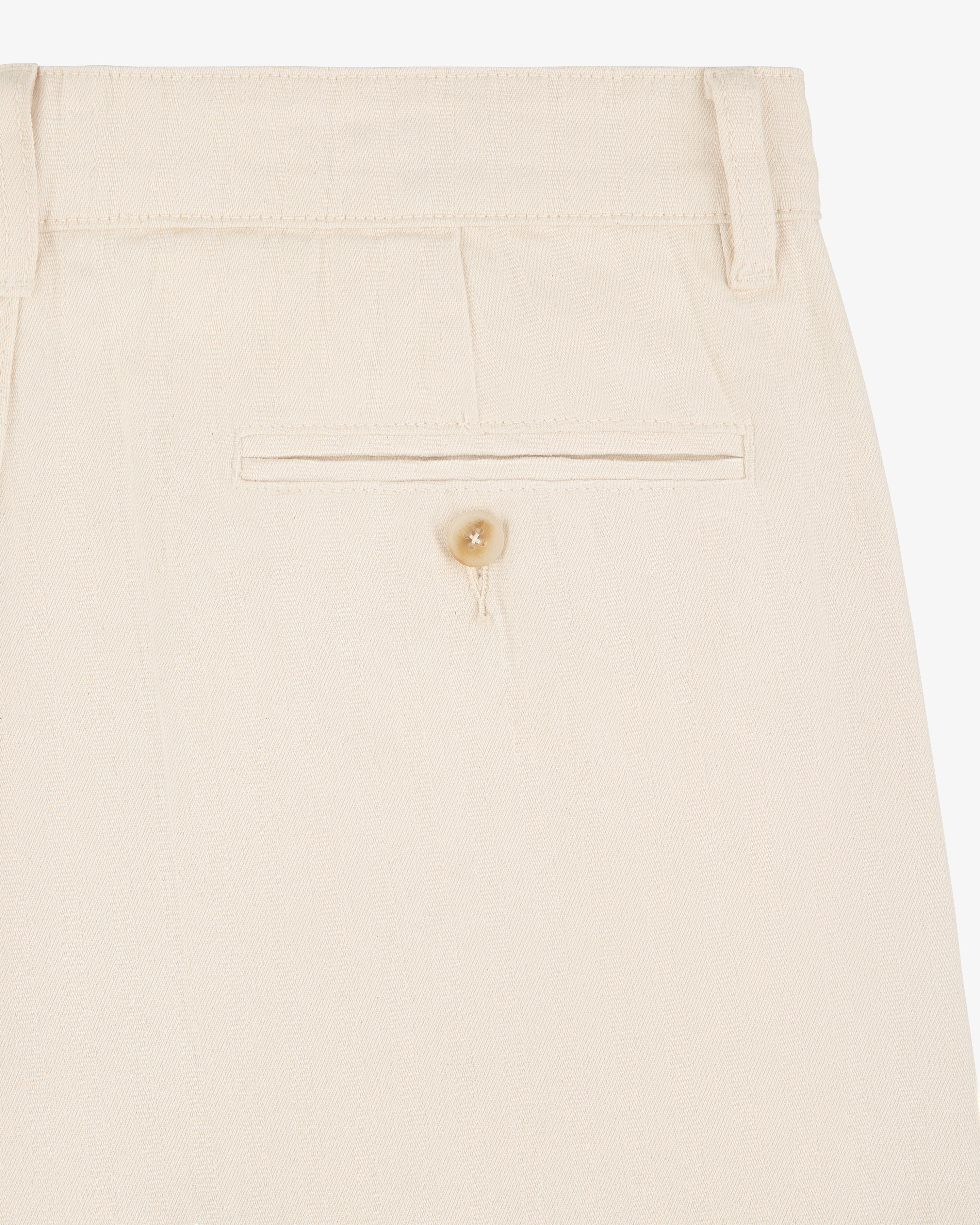 Close-up of Single Pleated Pant in beige, highlighting the back pocket with button and belt loop at the waistband.
