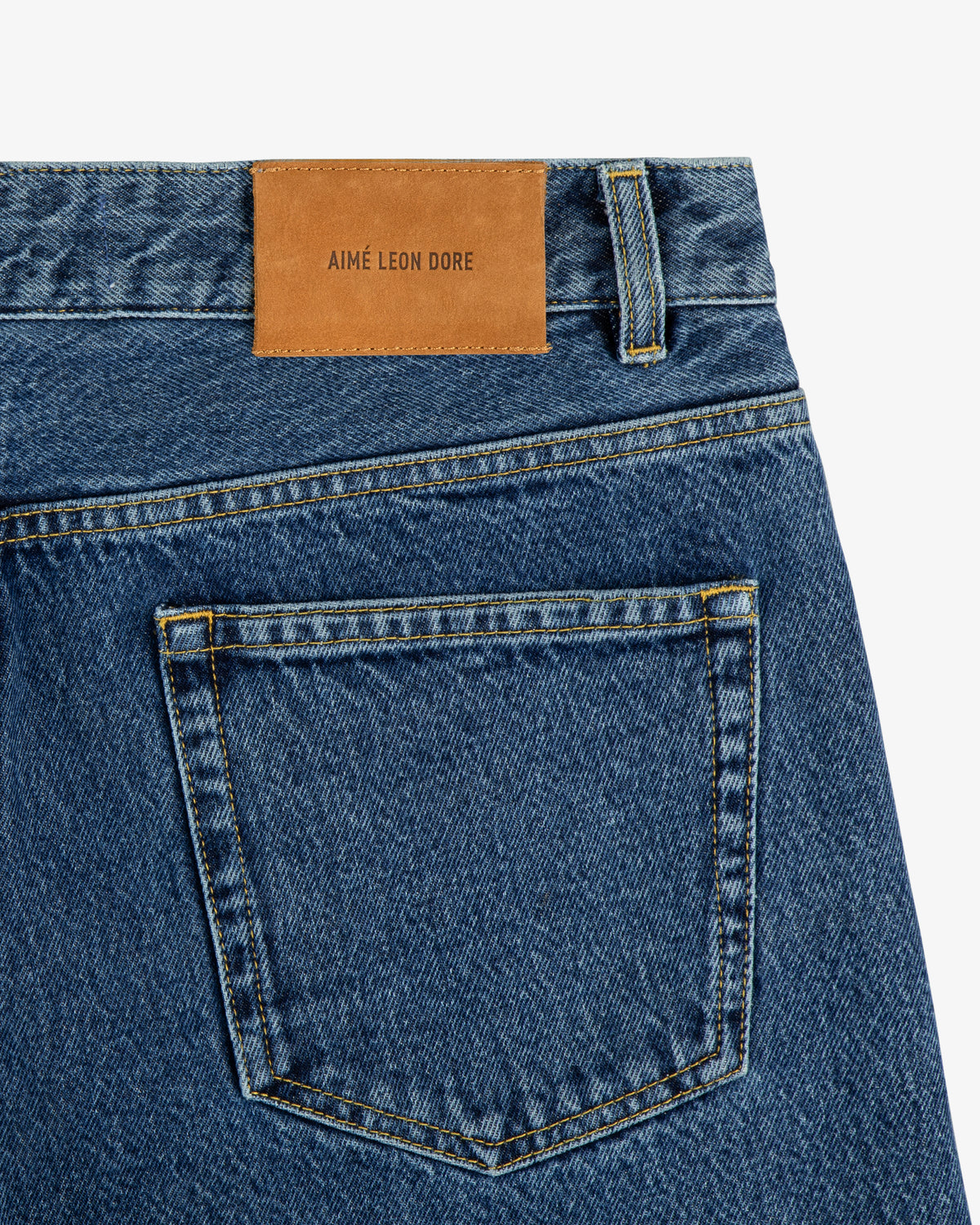 Back pocket of ALD Straight Fit Denim with a brown leather patch labeled AIMÉ LEON DORE above the pocket.