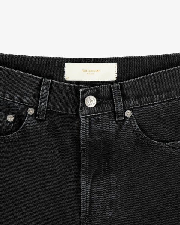 Close-up of the waistband and front button of ALD Straight Fit Denim in black, showing a white label inside.