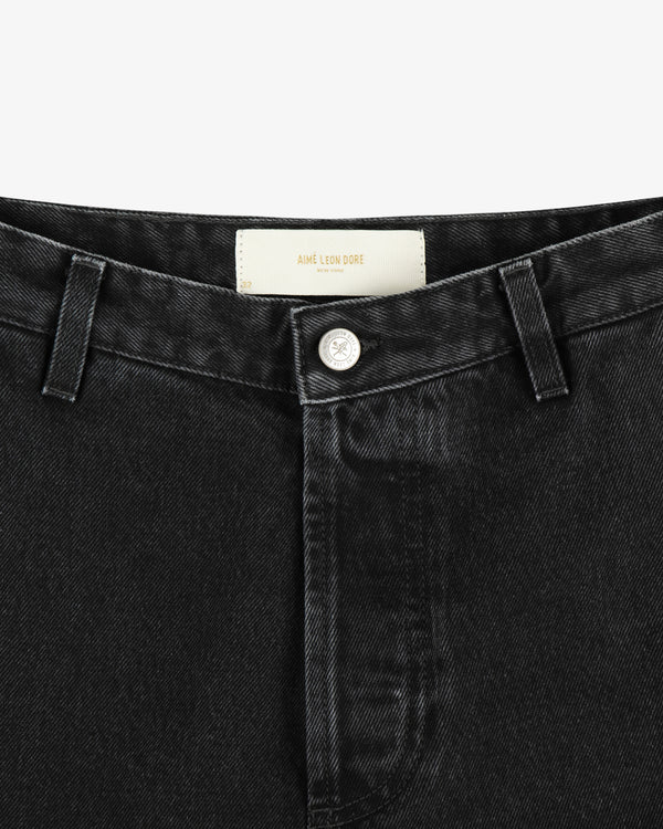 Close-up of the waistband and button of black Denim Carpenter Pant featuring an Aimé Leon Dore label inside.