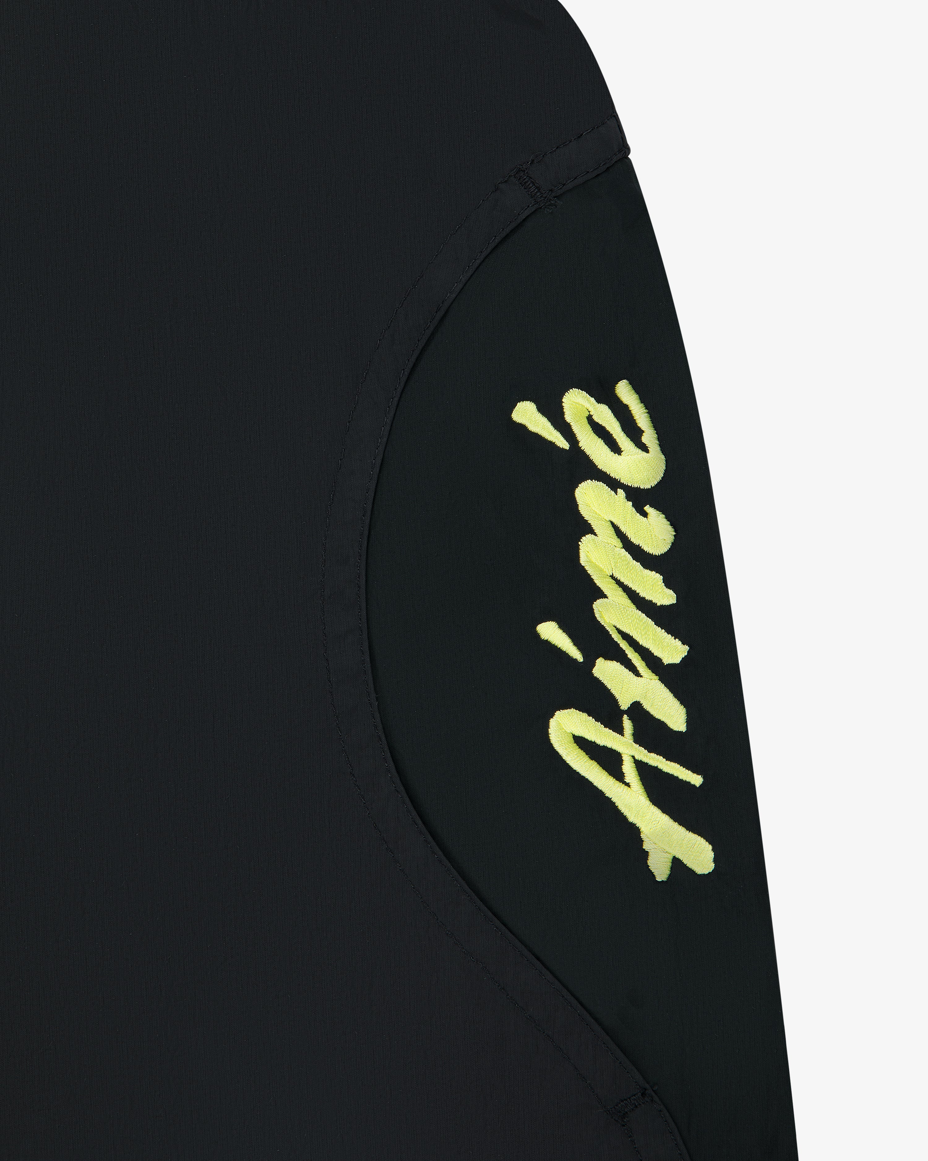 Black Paneled Sport Short with ‘Aimé’ in yellow cursive on a curved fabric panel.