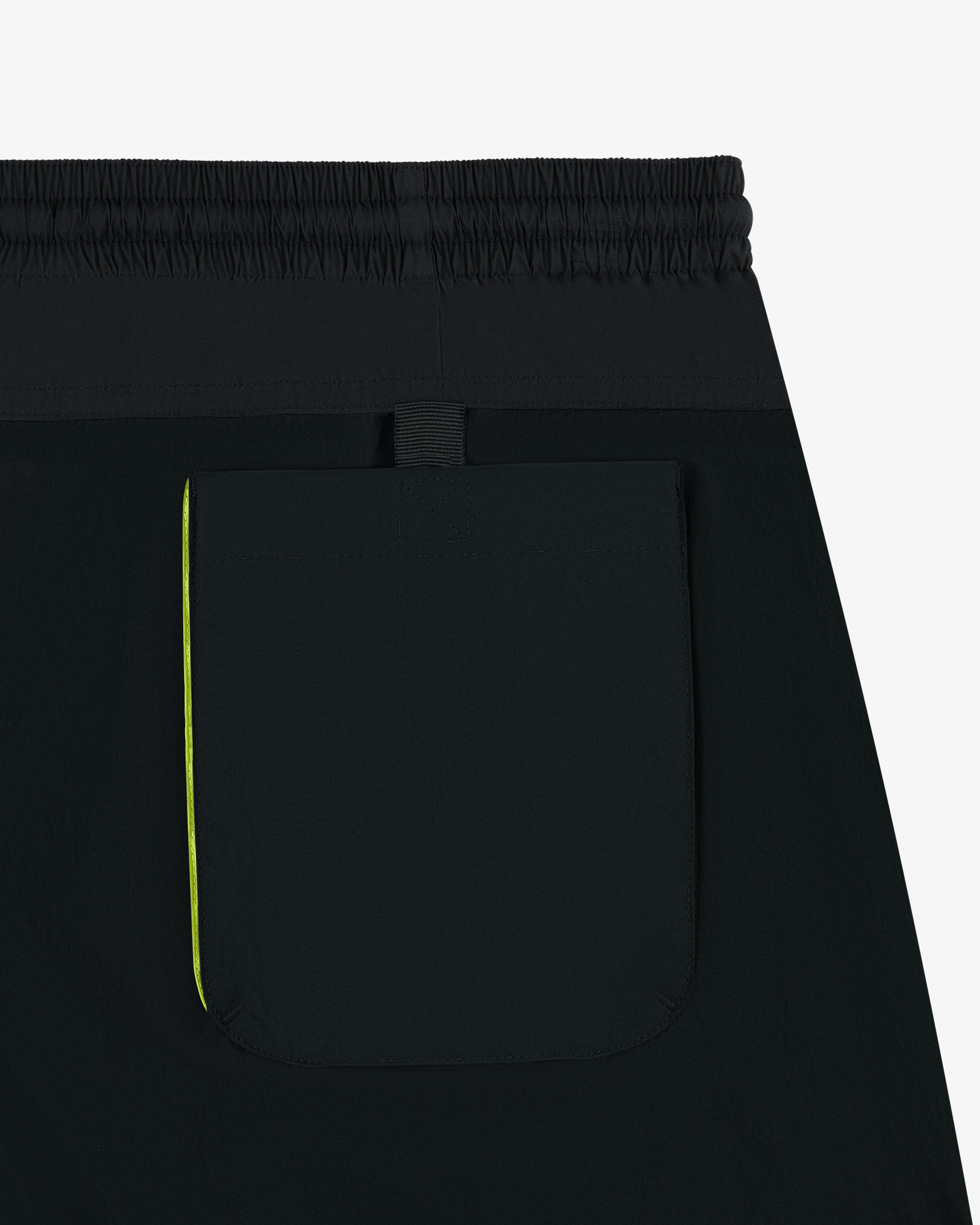 Close-up of Paneled Sport Short in black with elastic waistband, back pocket, and small yellow side accent.