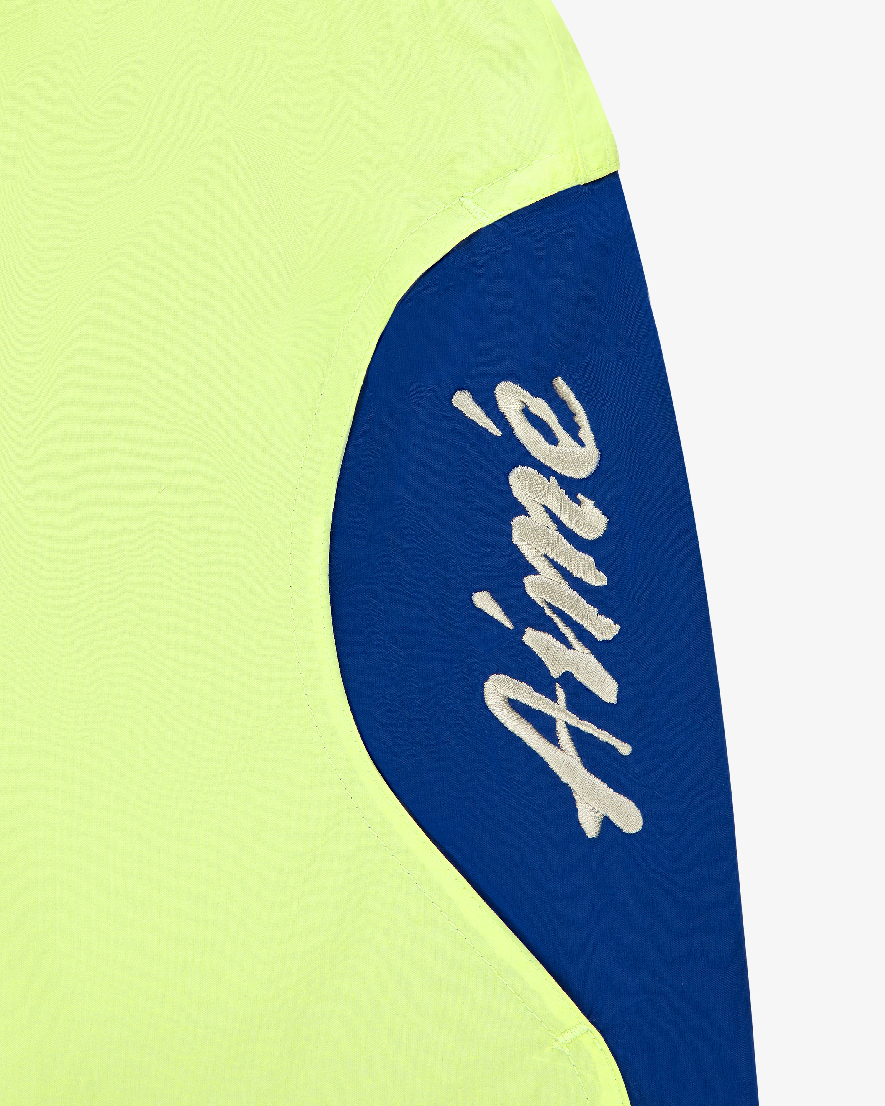 The Paneled Sport Short features blue and yellow fabric with “Aimé” embroidered in white script on the blue.