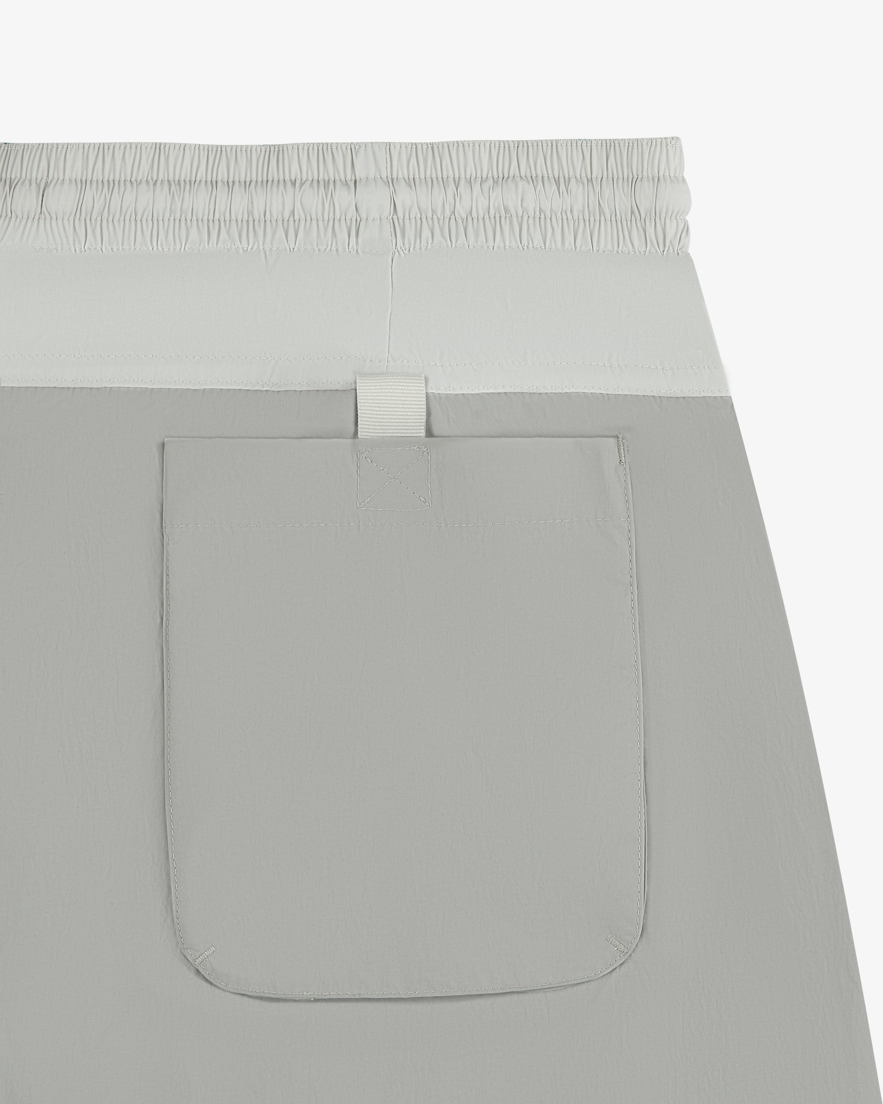 Close-up of Paneled Sport Short in light gray with elastic waistband and single back pocket.