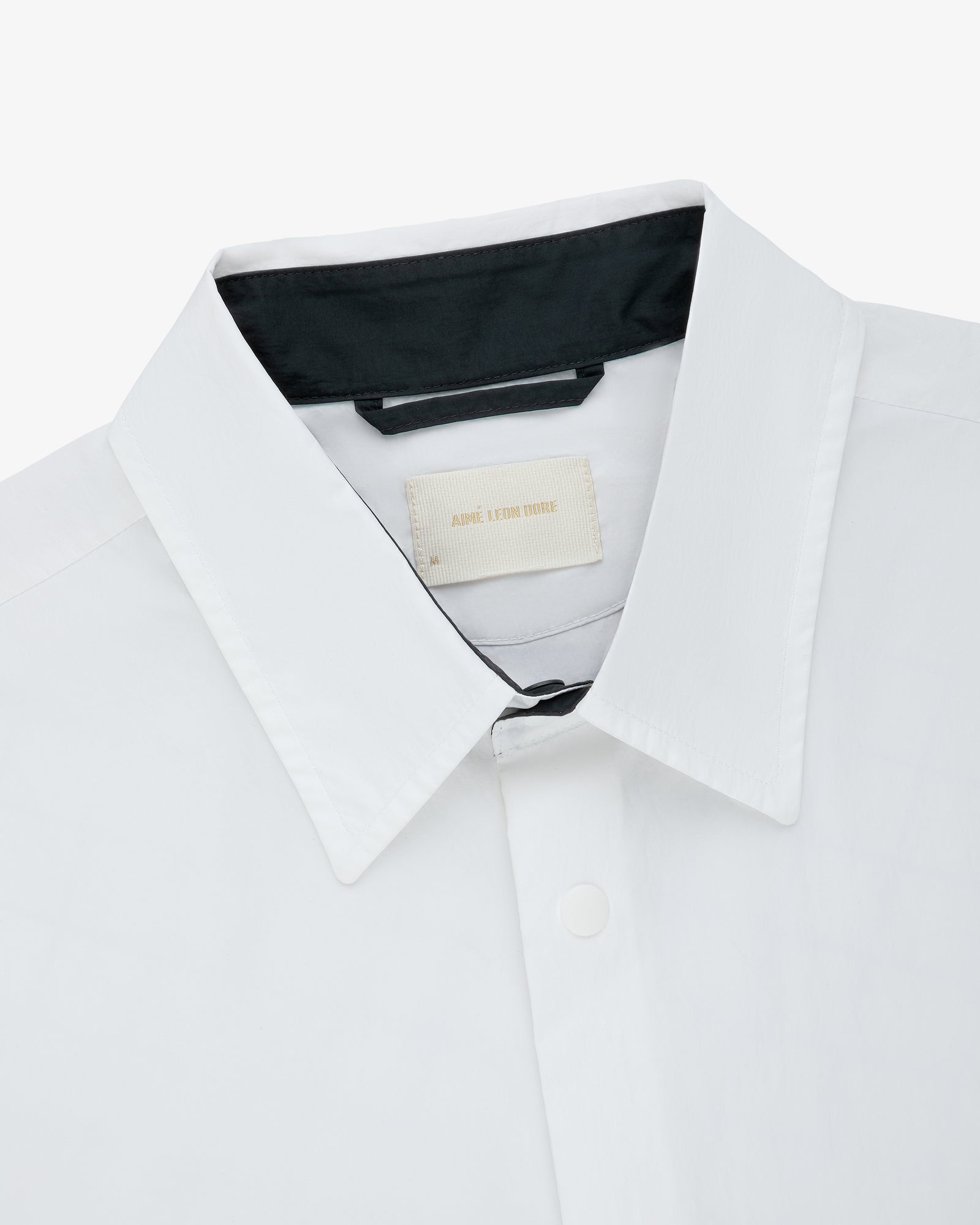 Colorblock Sport Shirt with a white collar, black lining, beige tag at neck, and top button closure.