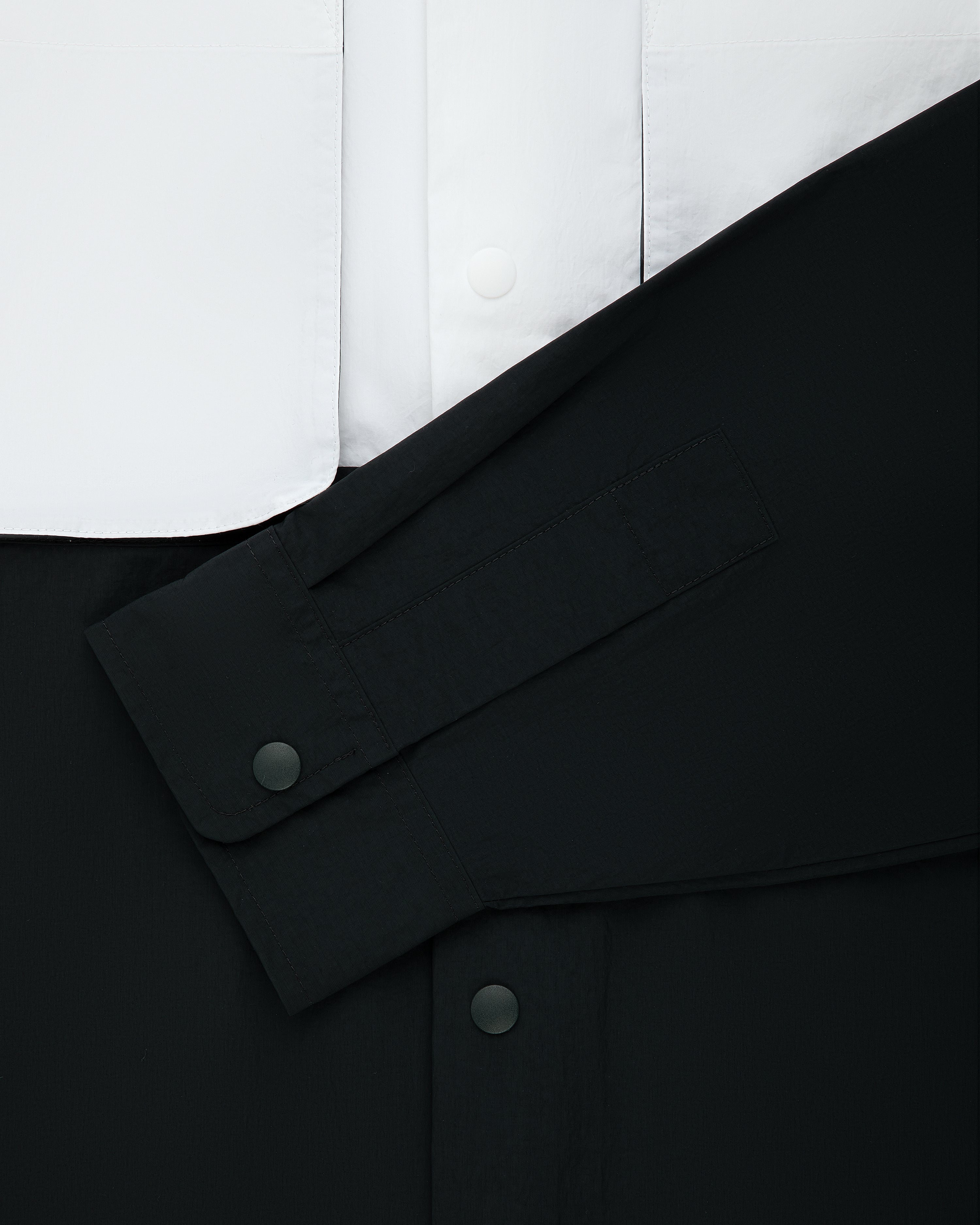Colorblock Sport Shirt features a black sleeve with snaps over white, both in smooth fabric with matching buttons.