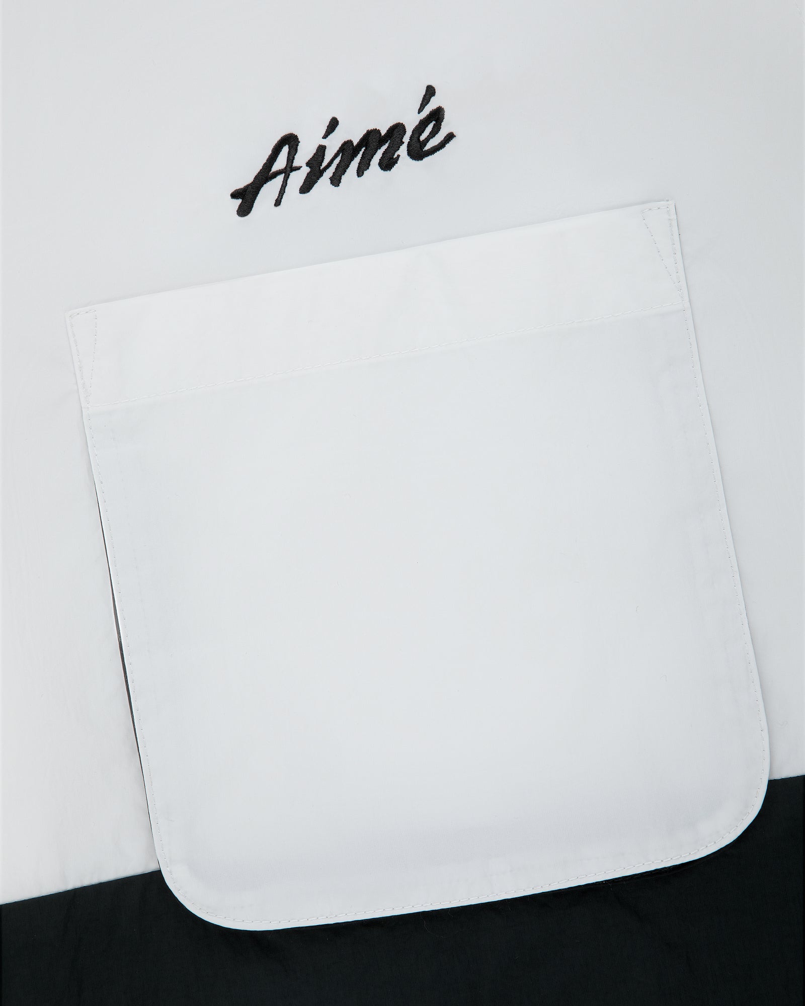 Colorblock Sport Shirt with a white pocket and “Aimé” embroidered in black above the pocket.