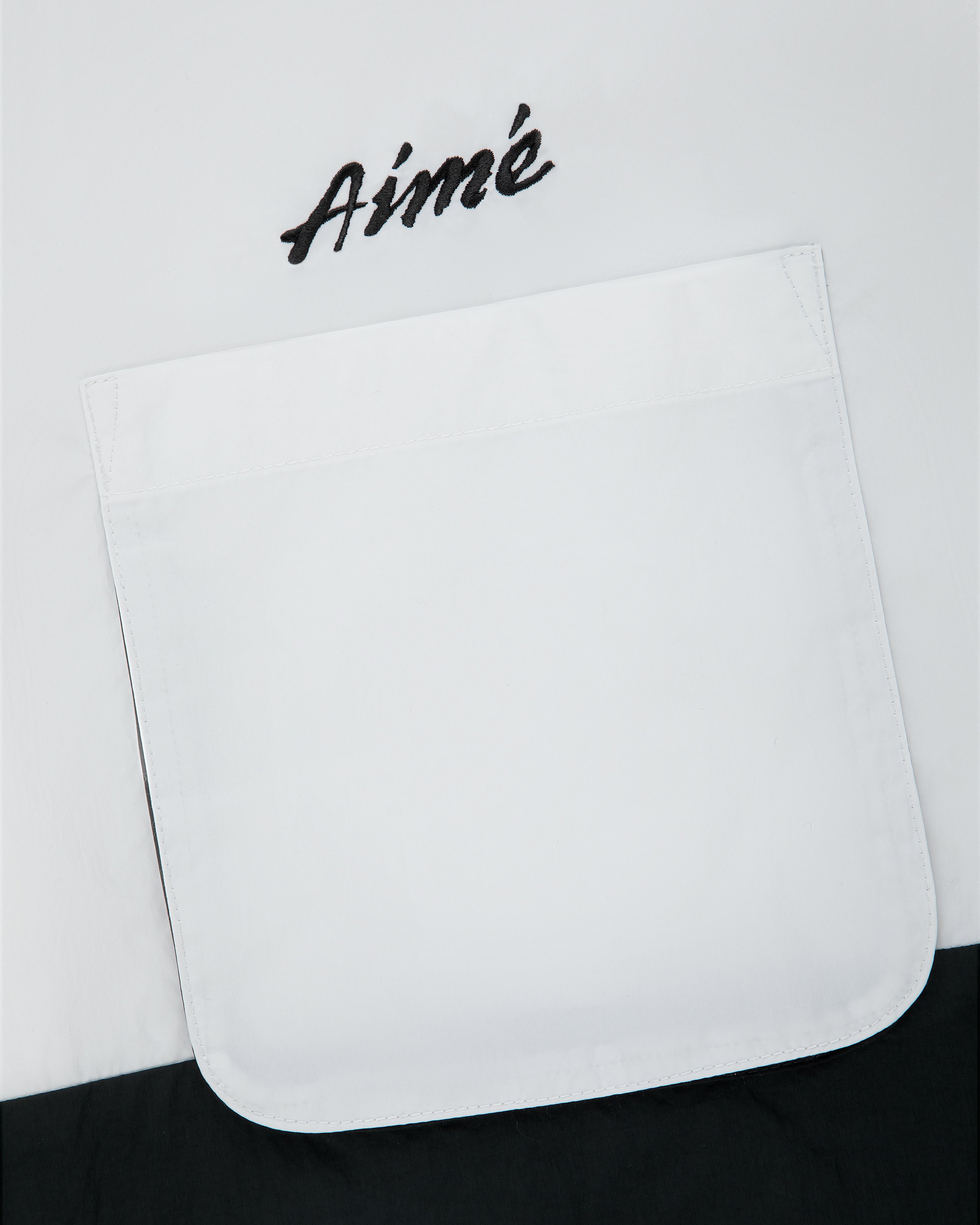 Colorblock Sport Shirt with a white pocket and “Aimé” embroidered in black above the pocket.