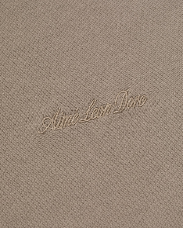 Beige Embroidered Logo Tee with Aimé Leon Dore in light cursive embroidery at the center.