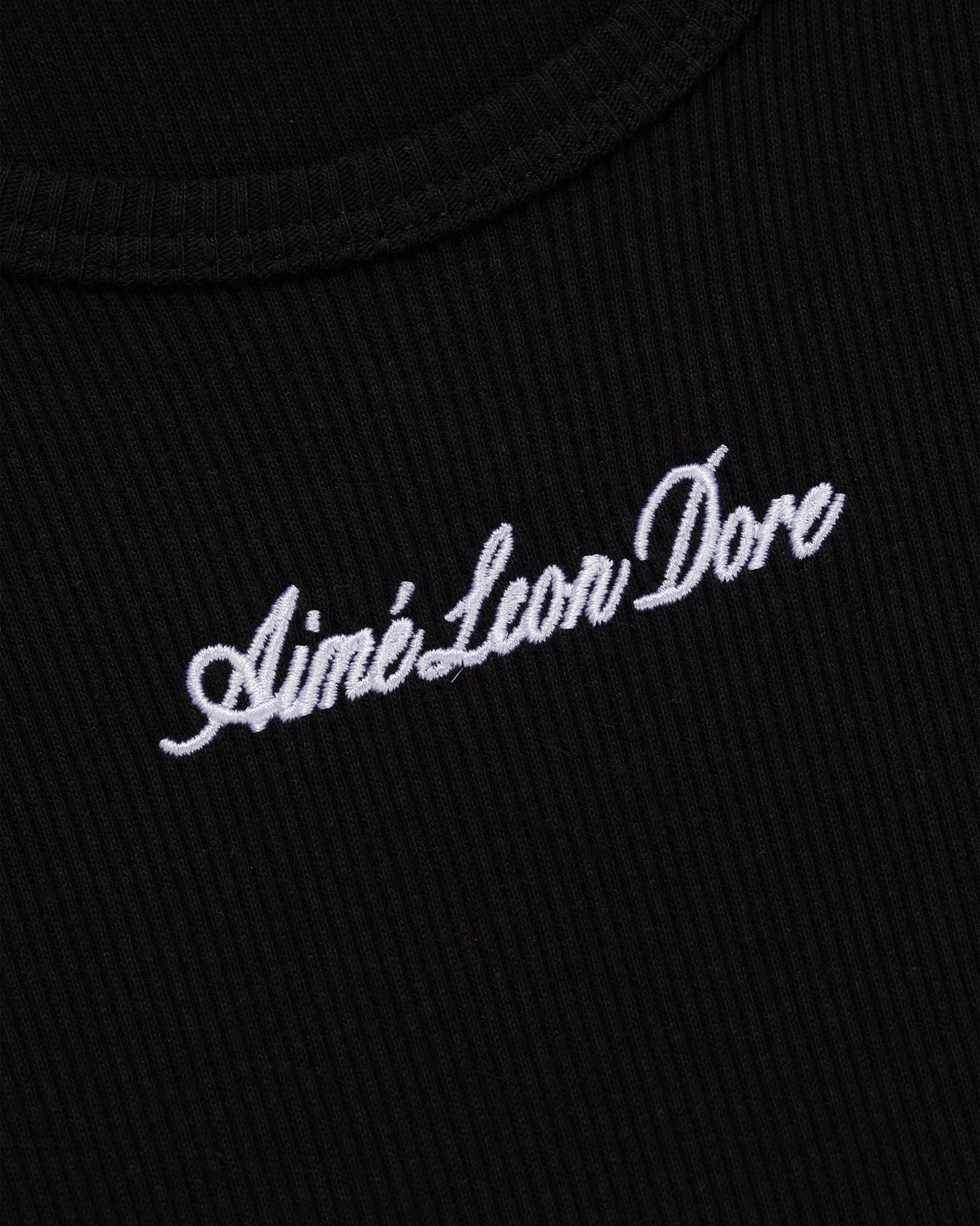 Close-up of black ribbed Embroidered Logo Tank Top with Aimé Leon Dore in white script.