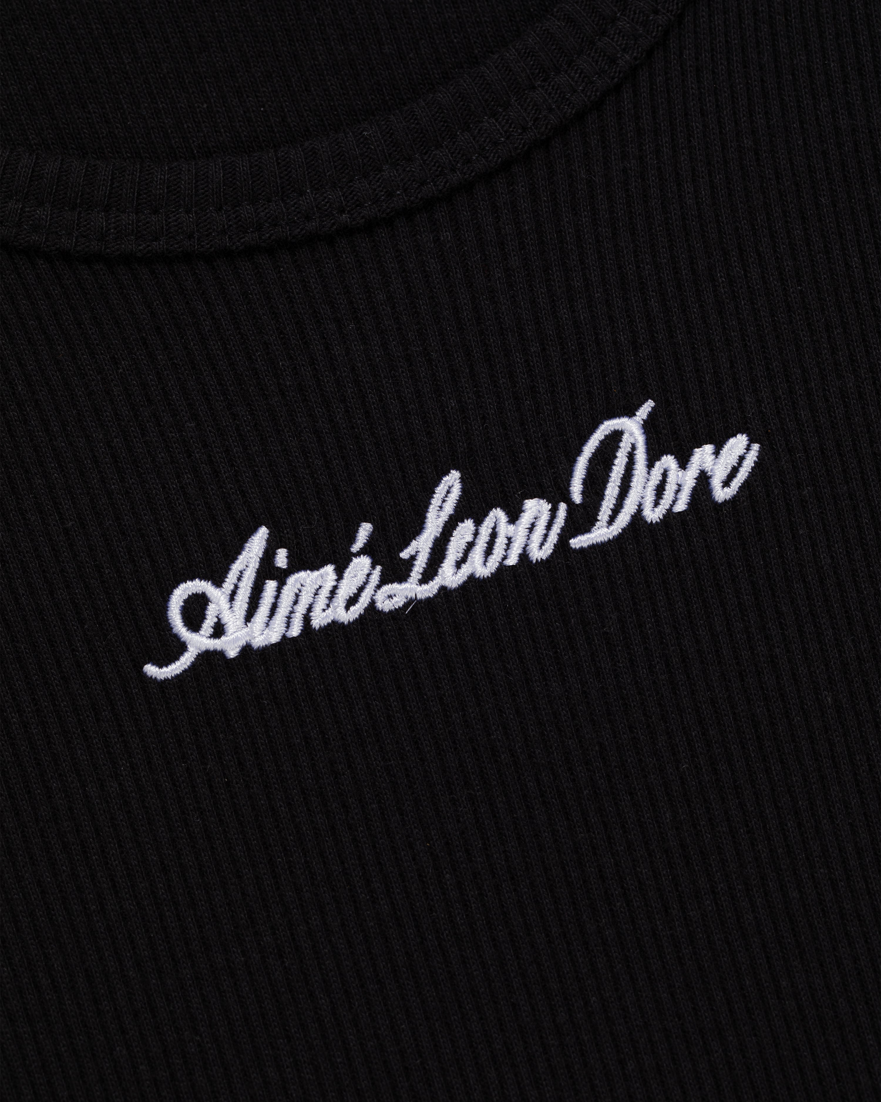 Close-up of black ribbed Embroidered Logo Tank Top with Aimé Leon Dore in white script.