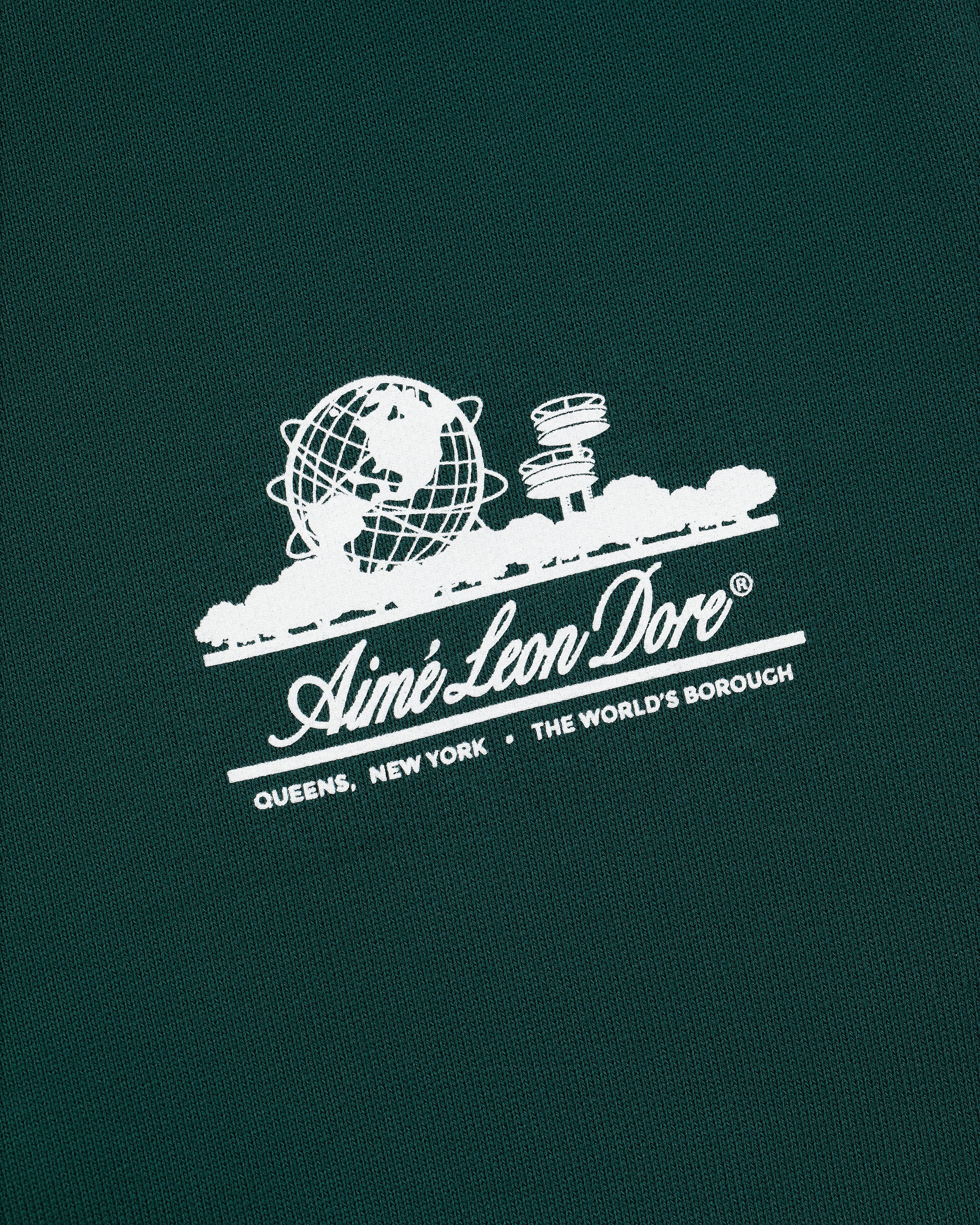 Green Unisphere Sweatpants with white Aimé Leon Dore logo, globe, cityscape, and "QUEENS, NEW YORK - THE WORLDS BOROUGH" text.