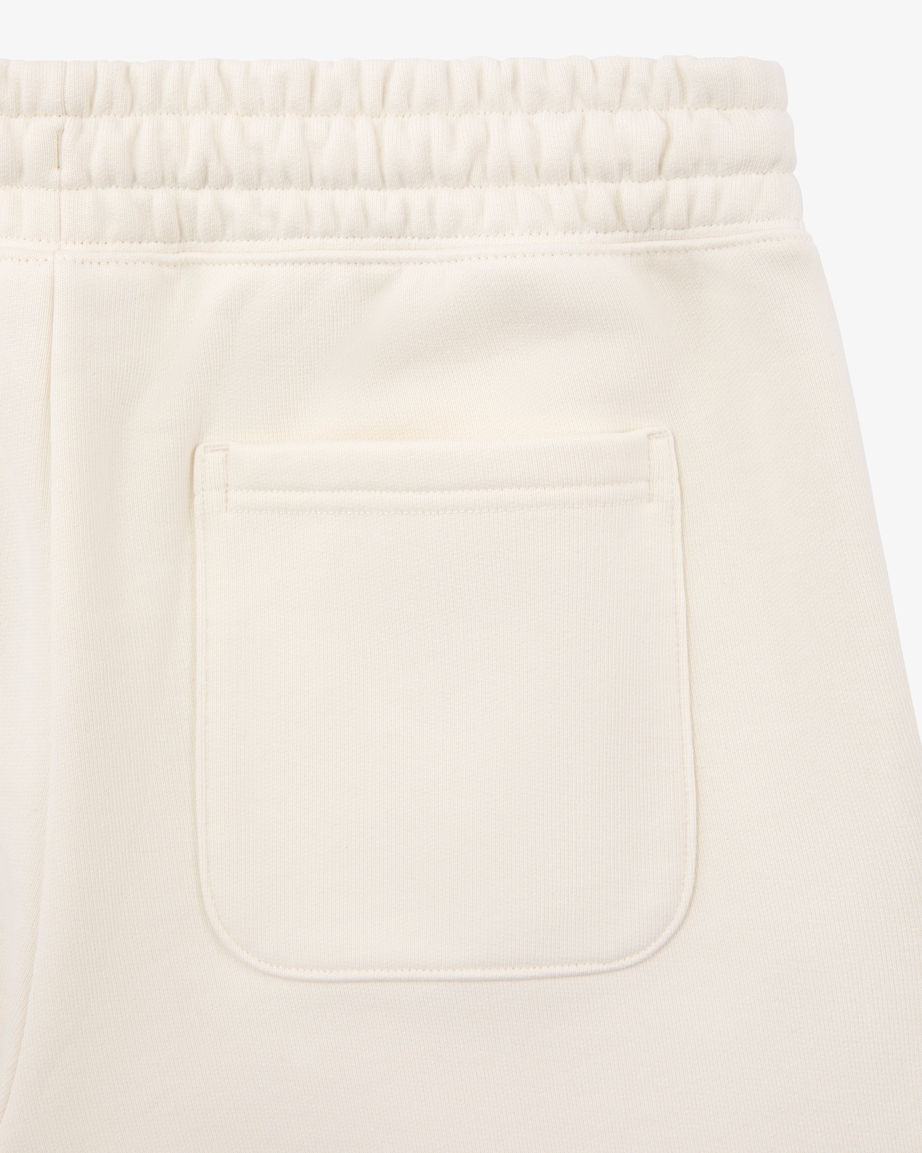 Close-up of Unisphere Sweatpants in cream with an elastic waistband and a single back patch pocket.