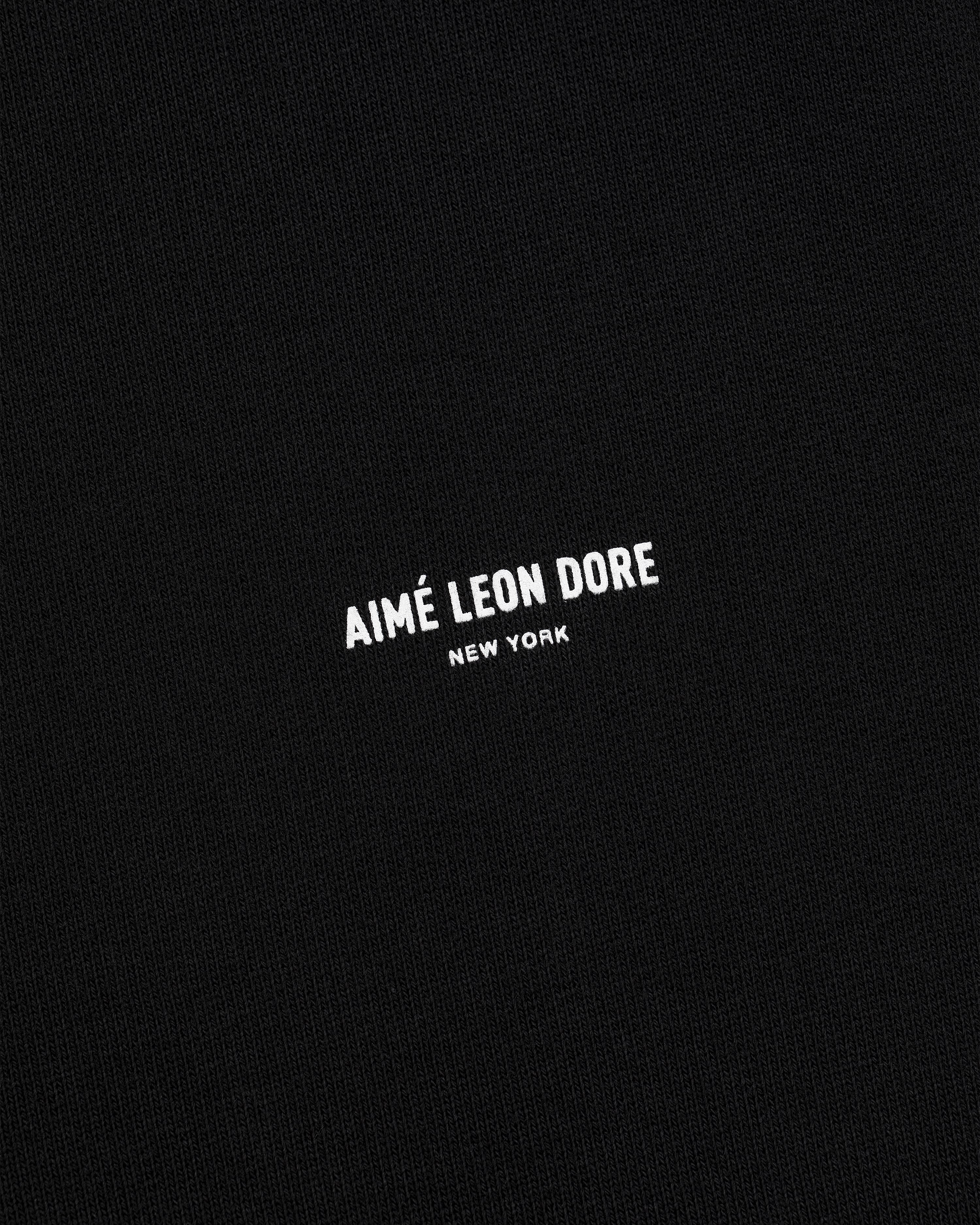 Black fabric sweatpants with small white AIMÉ LEON DORE NEW YORK logo centered on the front.