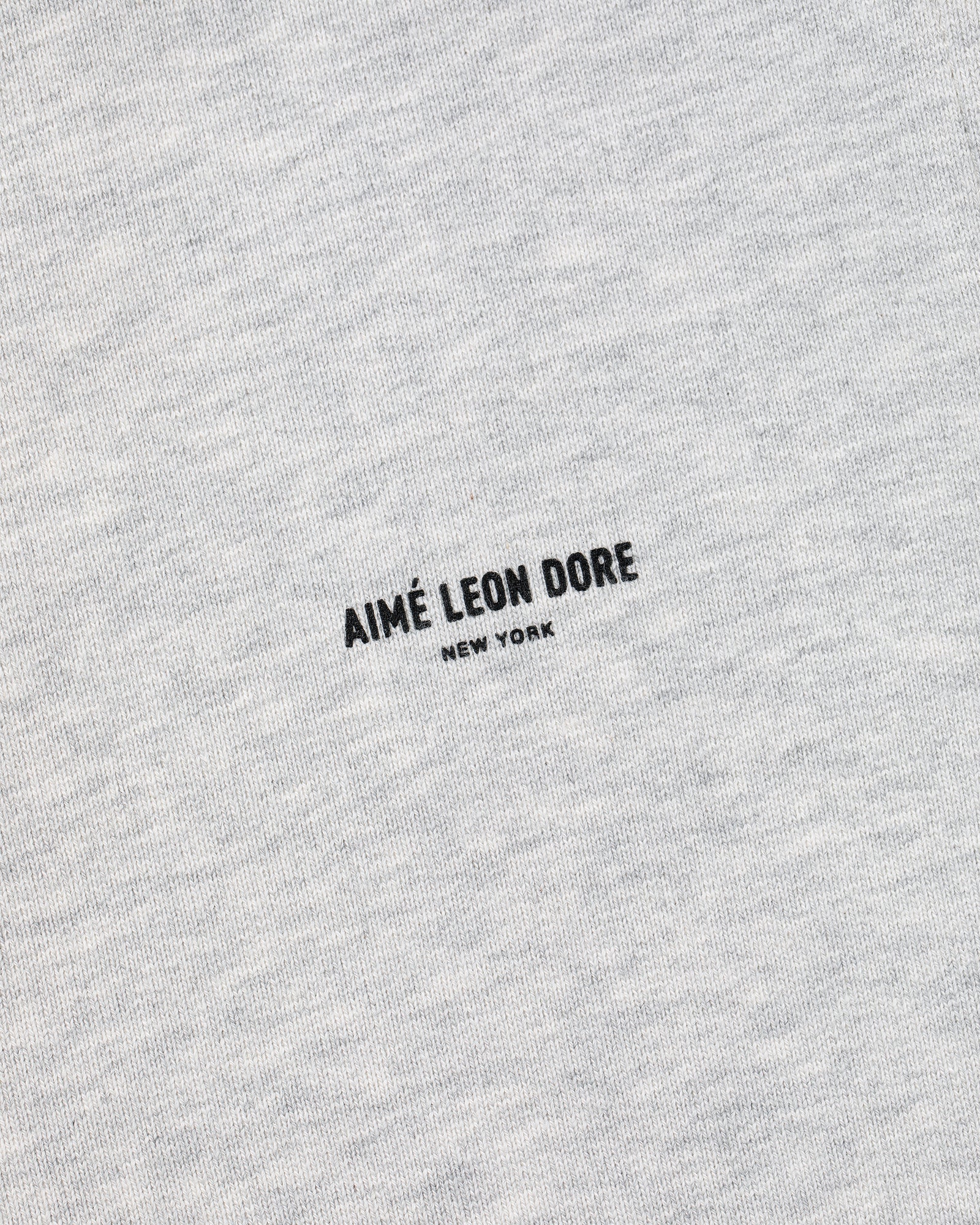 Close-up of heather gray Micro Logo Sweatpants with AIMÉ LEON DORE NEW YORK printed in black at the center.
