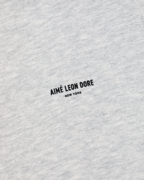 Close-up of heather gray Micro Logo Sweatpants with AIMÉ LEON DORE NEW YORK printed in black at the center.