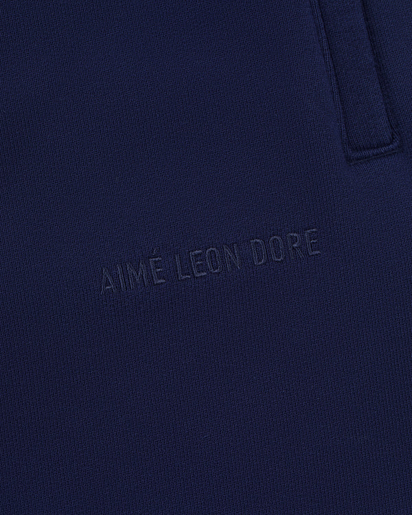 Close-up of Tonal Logo Sweatpants in navy blue with AIMÉ LEON DORE subtly embossed on the fabric.