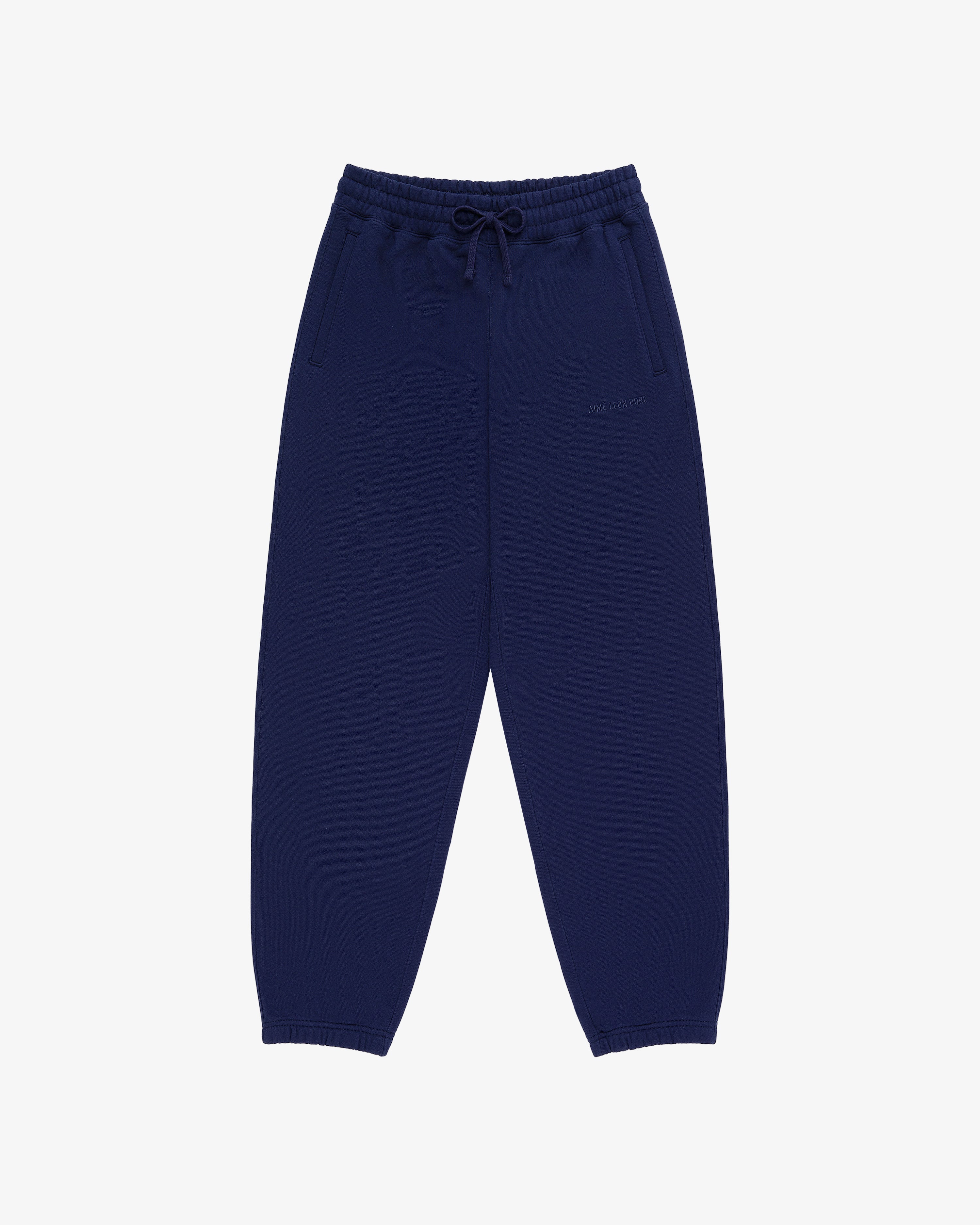 Tonal Logo Sweatpants in navy blue with elastic waistband, drawstring, side pockets, and elastic cuffs on white background.