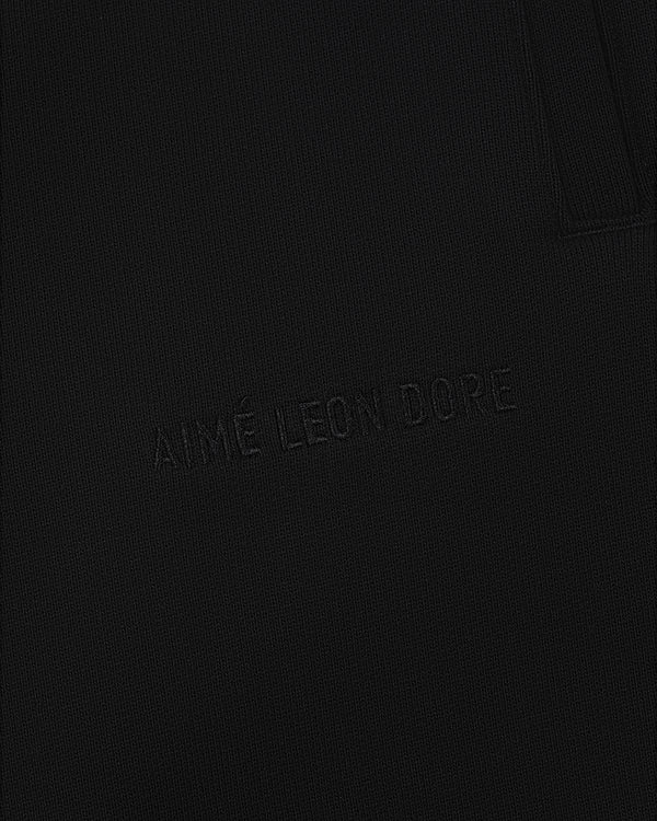 Close-up of Tonal Logo Sweatpants with AIMÉ LEON DORE subtly embroidered on black textured fabric.